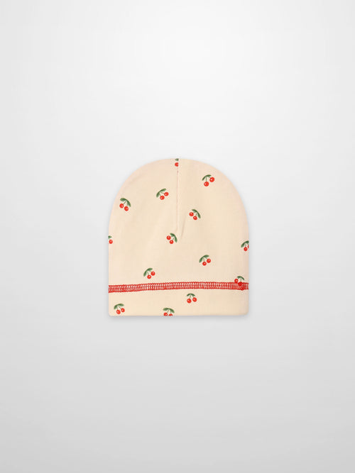 Red Cherry Hat for girls by Adee; beige knit cap with scattered red cherries pattern