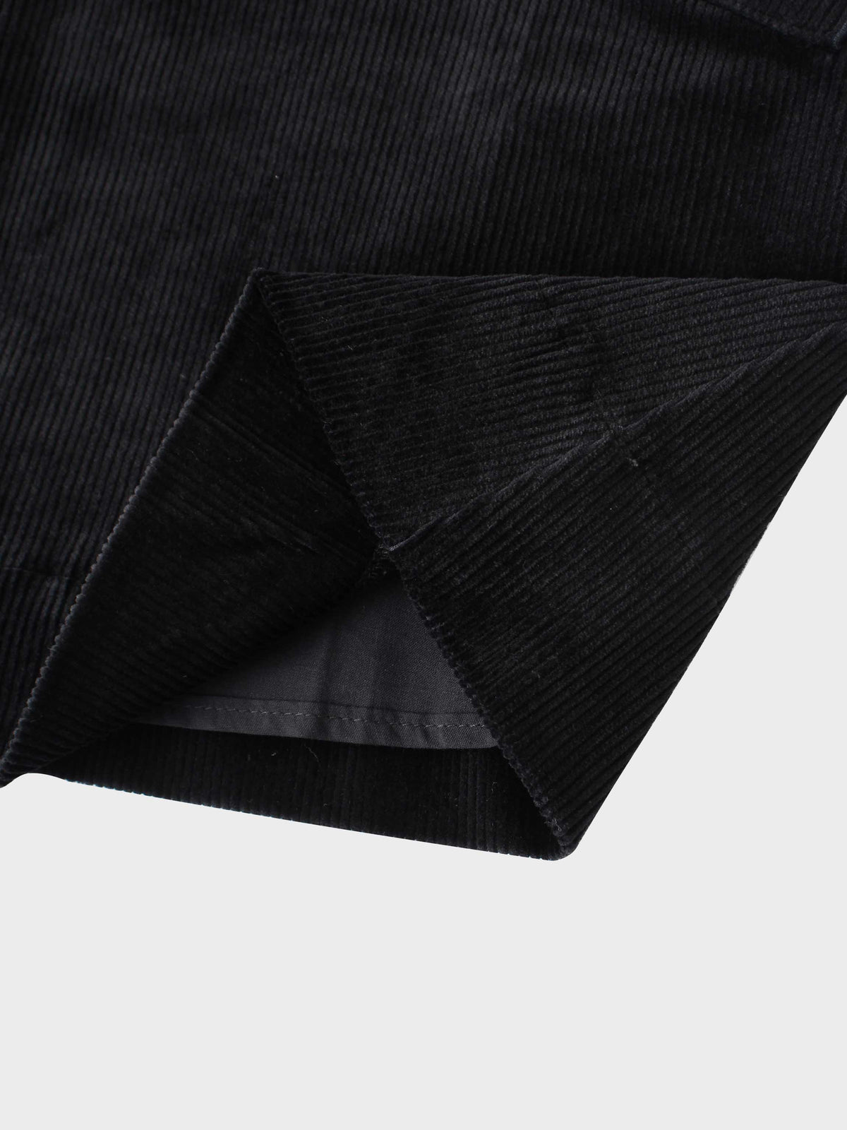 Corduroy Jumper - Black close-up of textured fabric with folded sleeve hem.
