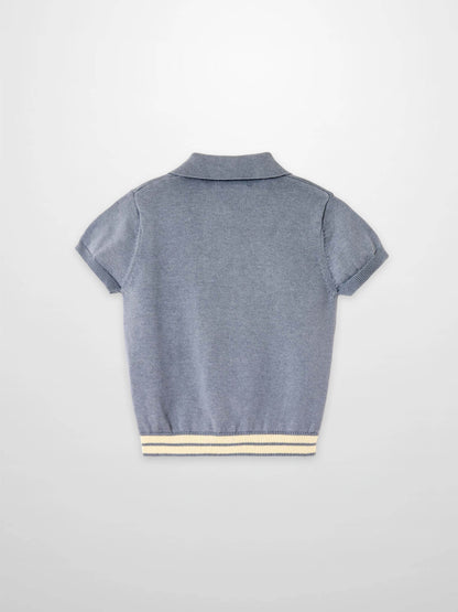 Back view of light blue knit sweater with short sleeves, polo collar, and striped hem.
