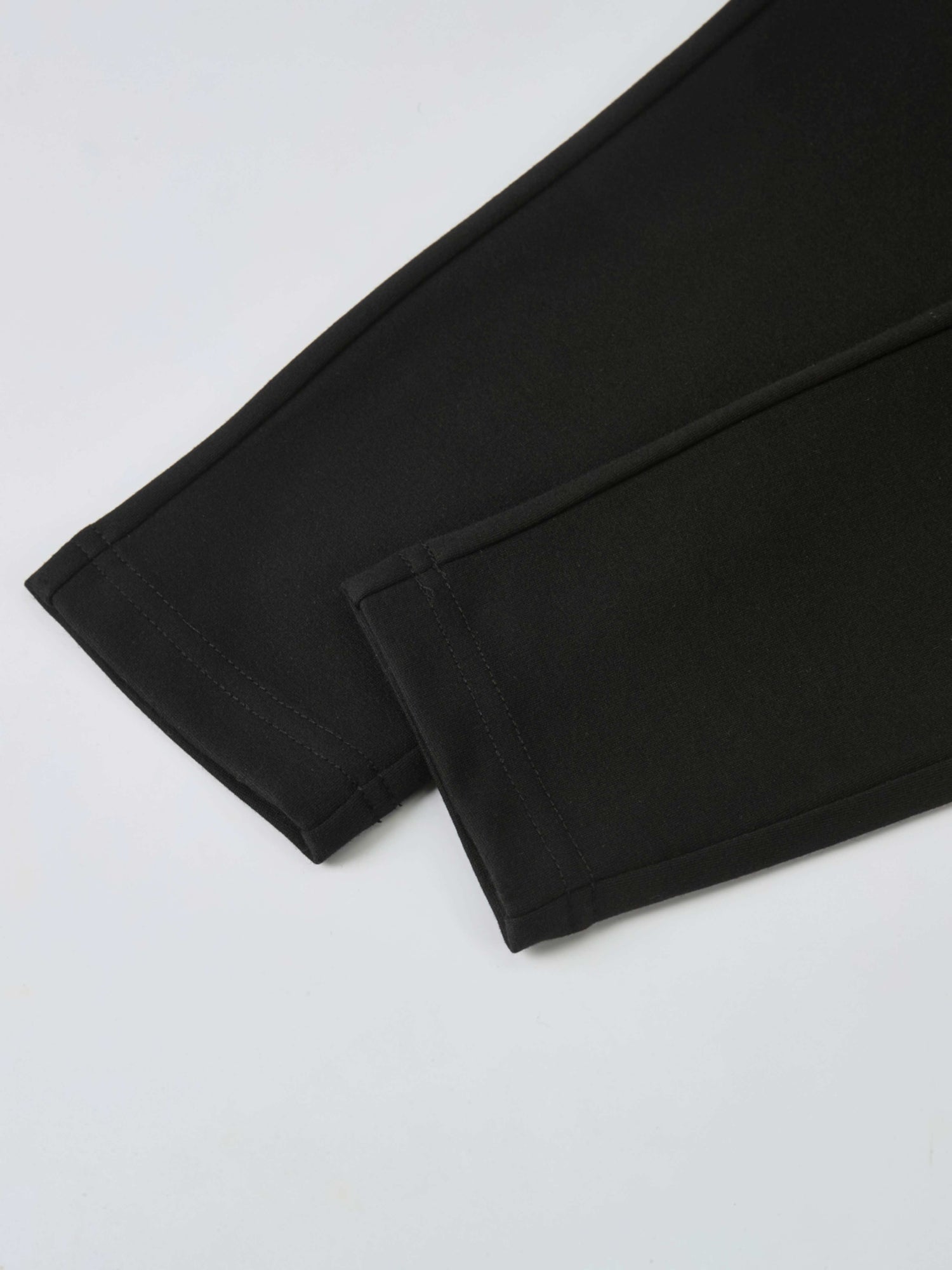 Dress pants for boys in black, dressy bottoms with neat stitched hems.