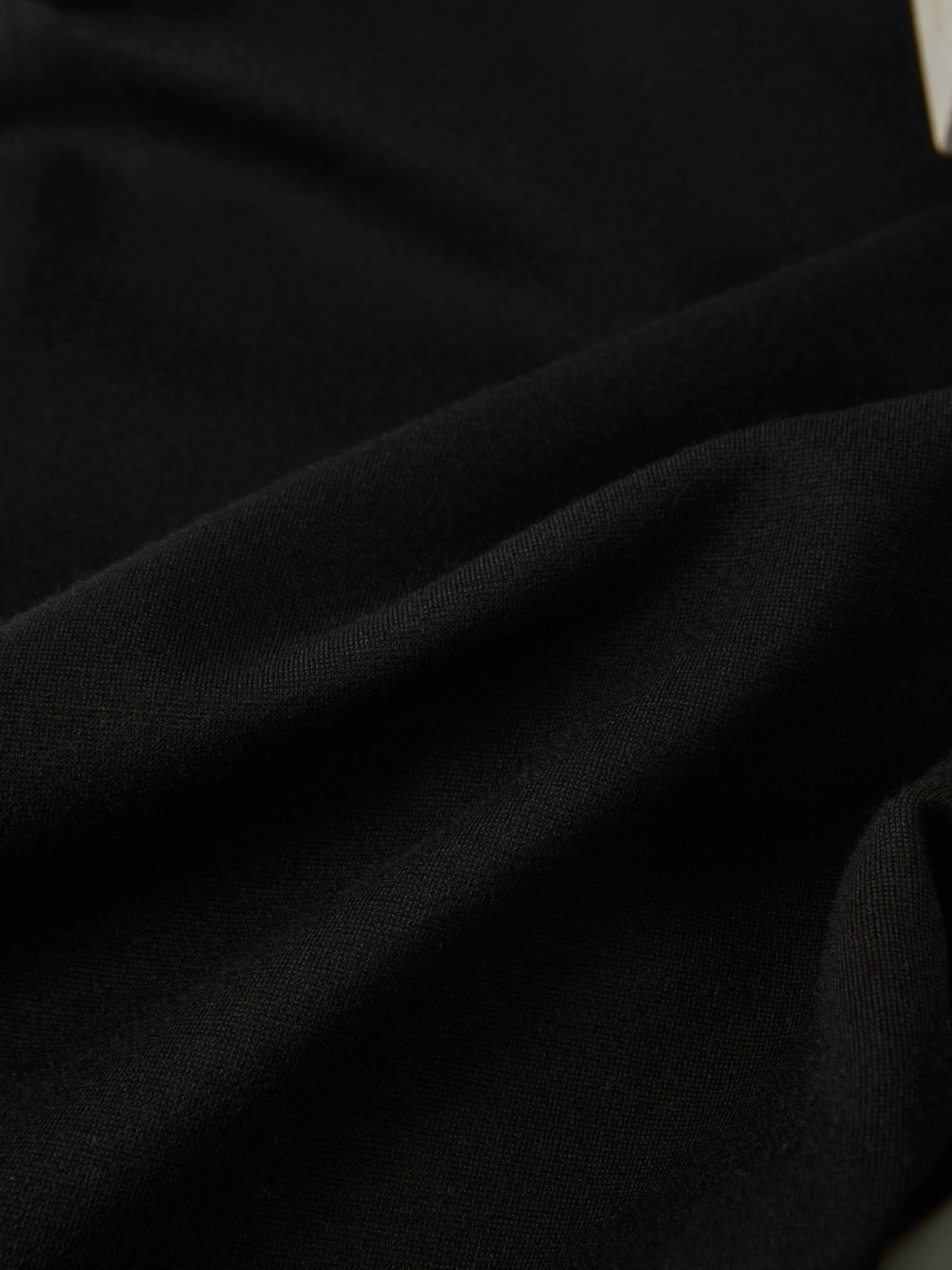 Dress pants black fabric close-up showing smooth textile texture