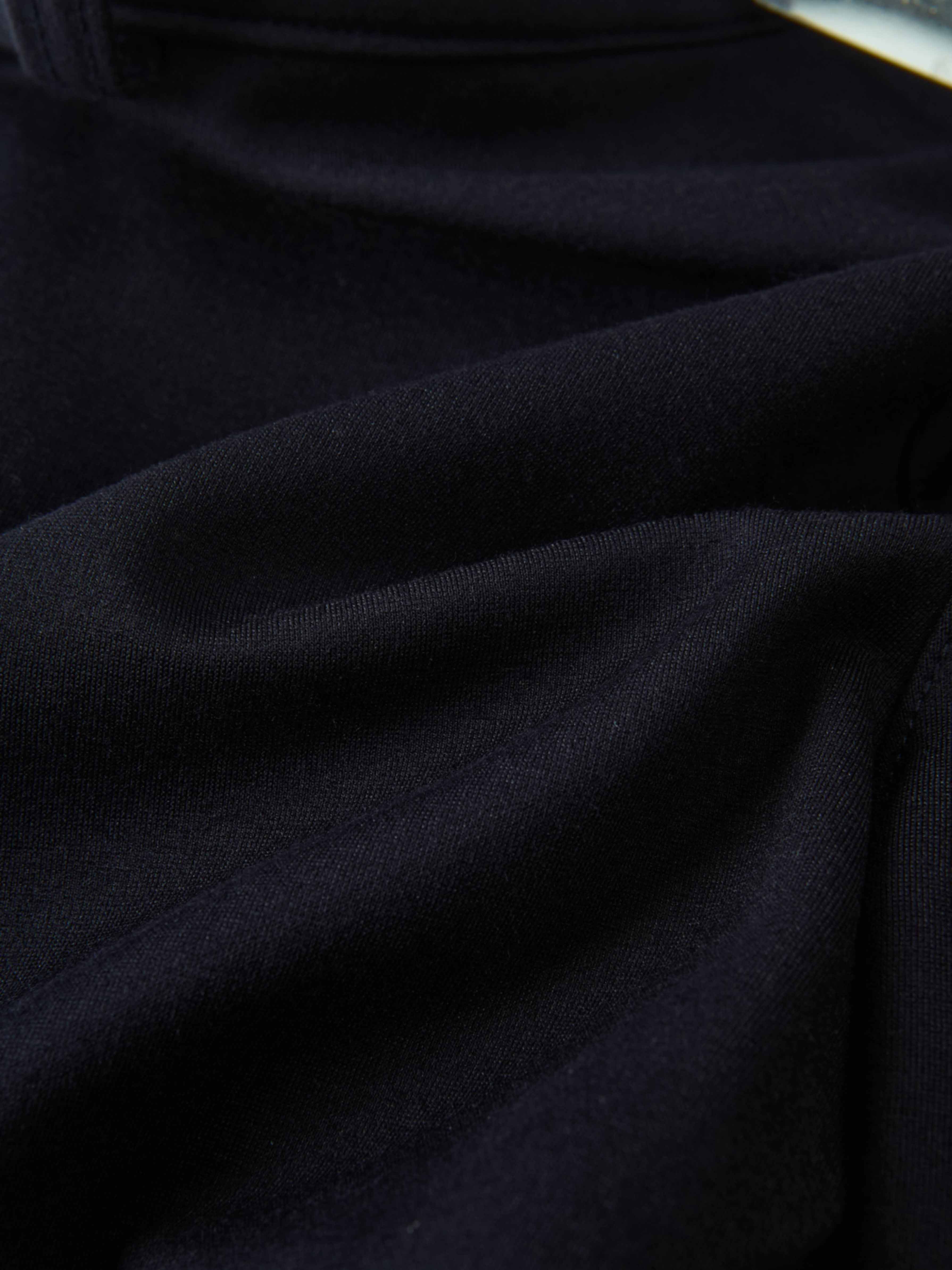 Dress pants for boys in navy fabric, close-up view of dark material