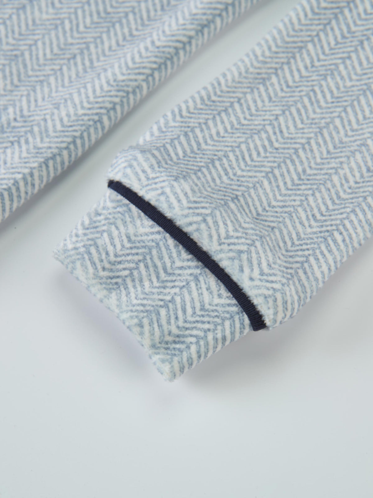 Boys pajamas in blue herringbone fabric with navy piping.