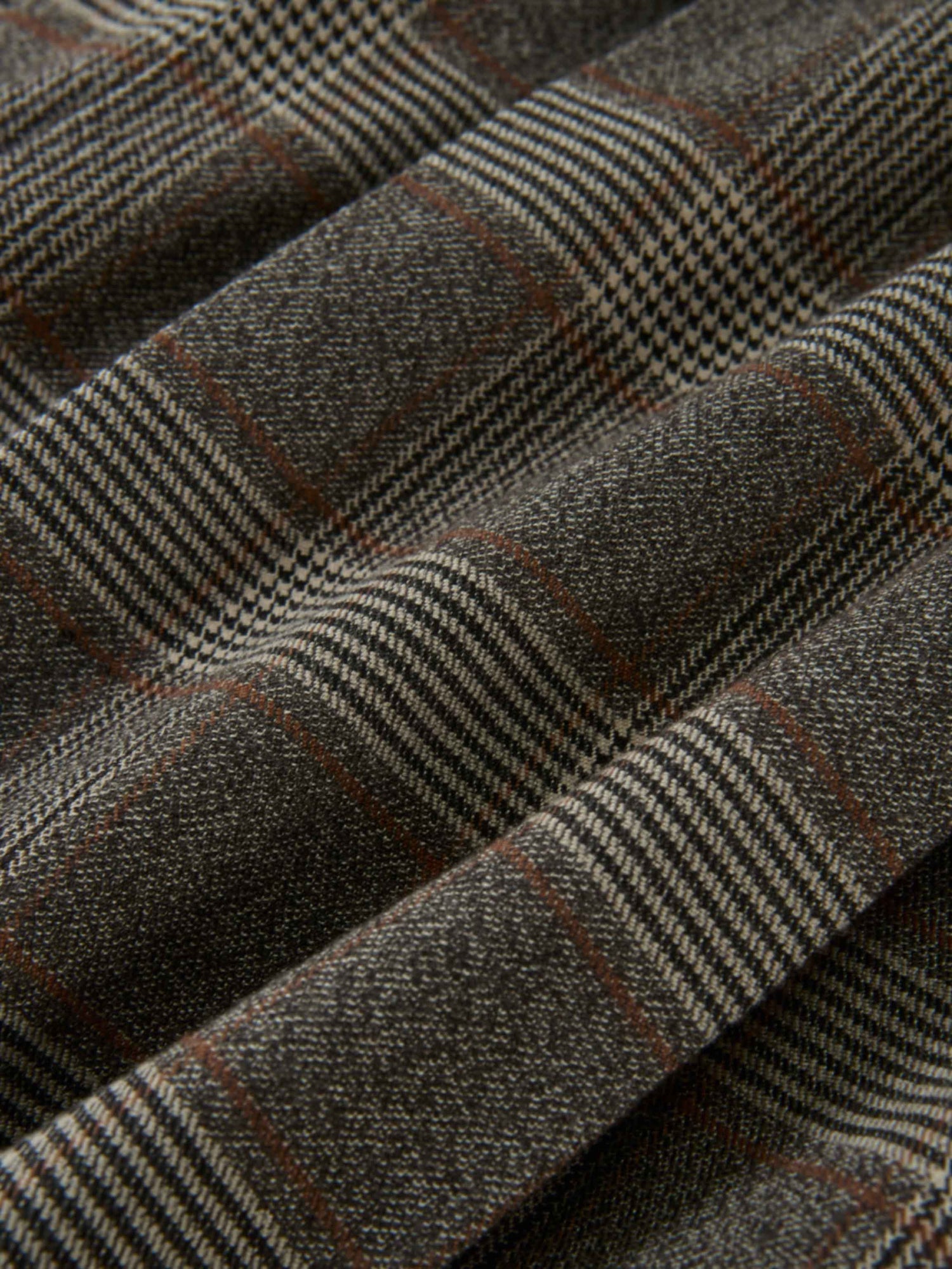 Plaid pleated skirt in grey fabric with brown lines, close-up texture.