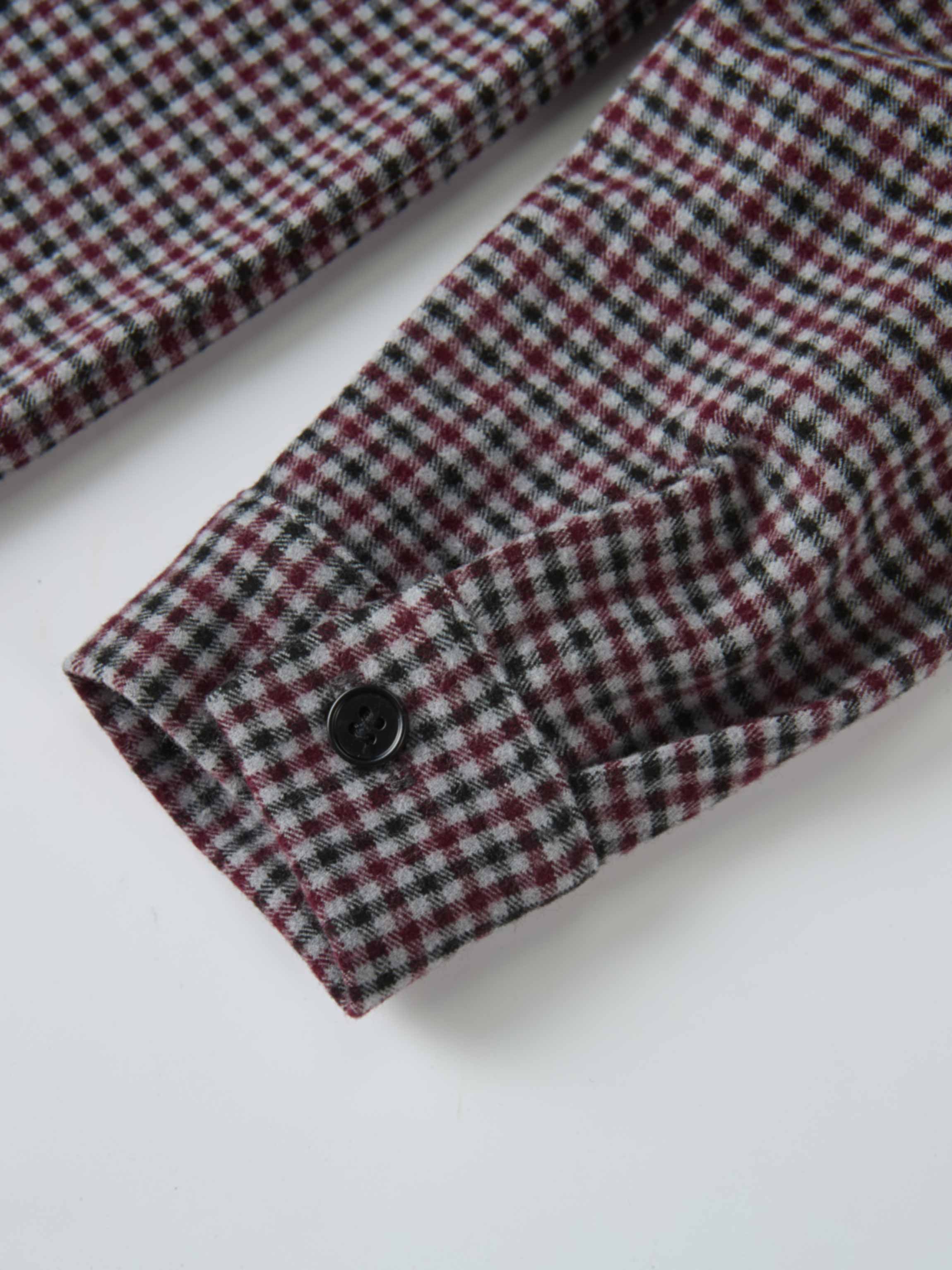 Gingham shirt for boys, grey check pattern; close-up of cuff with black button.