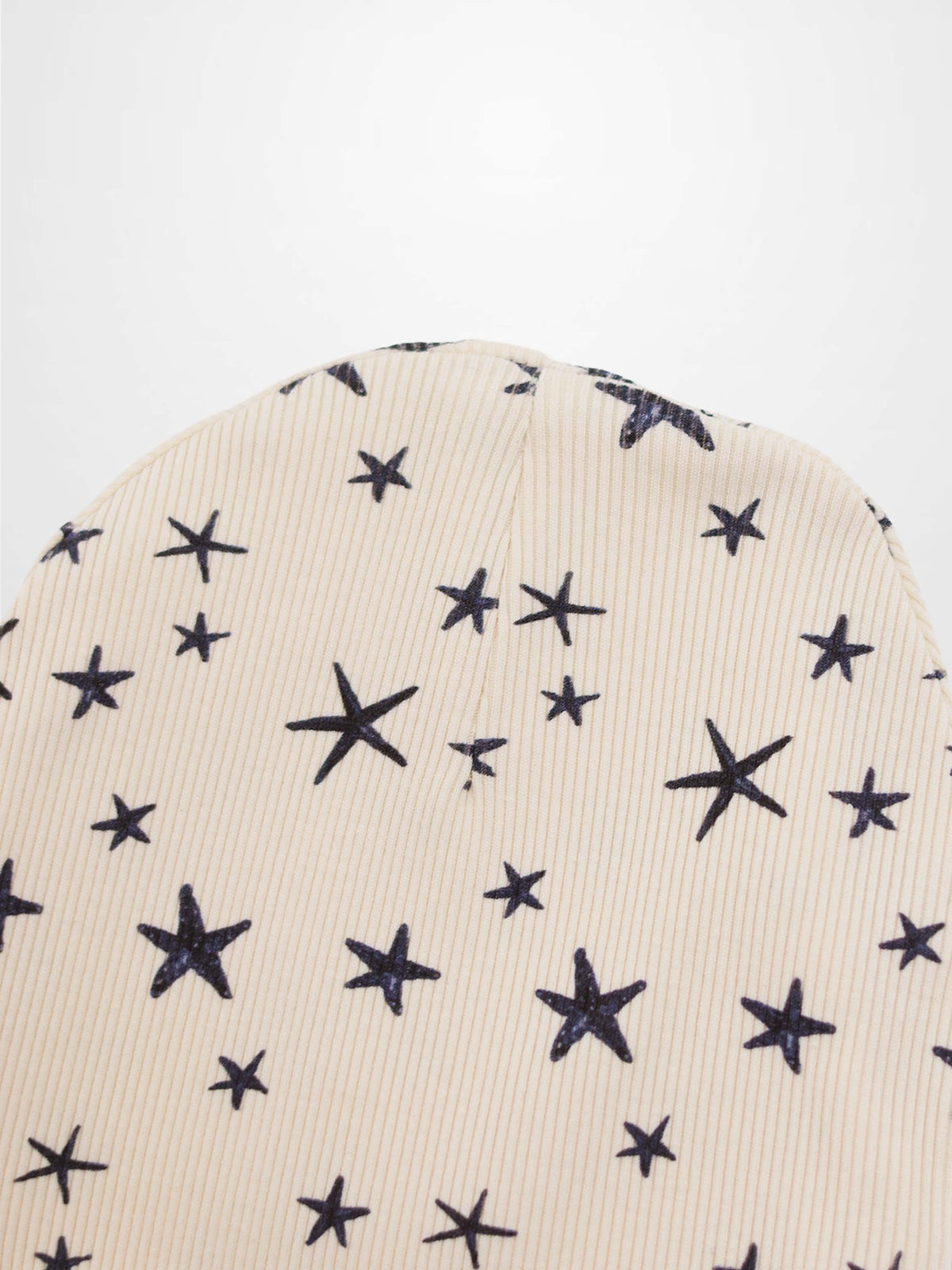 Star Beanie for boys by Adee, light beige knit hat with scattered navy star pattern and soft ribbed cuff.
