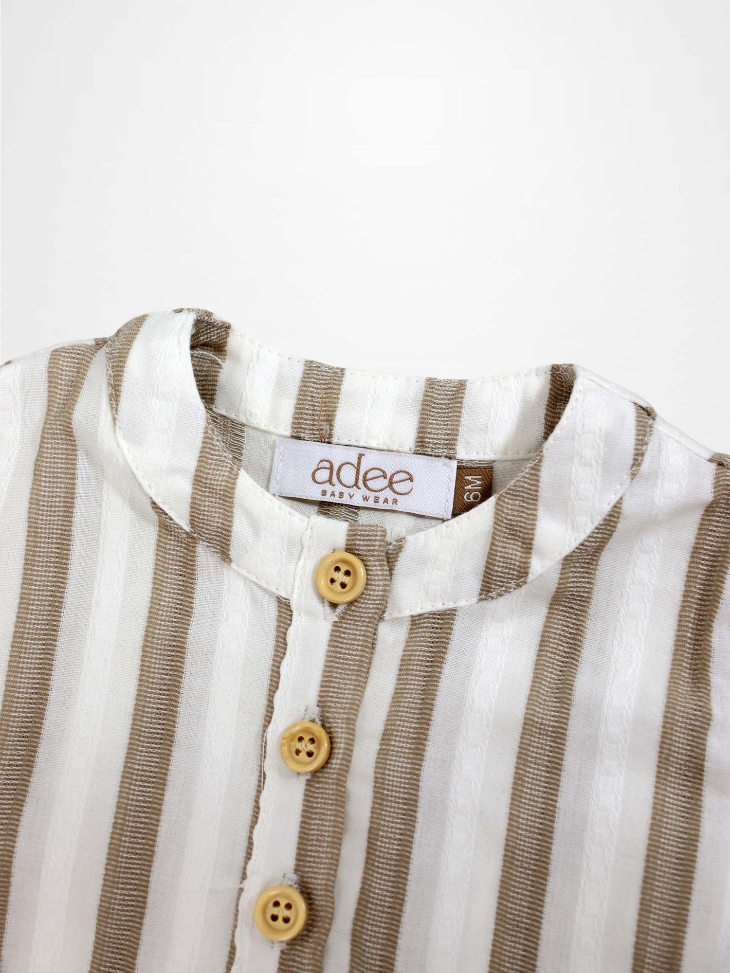 Tan and white striped baby romper with a mandarin collar and beige buttons.