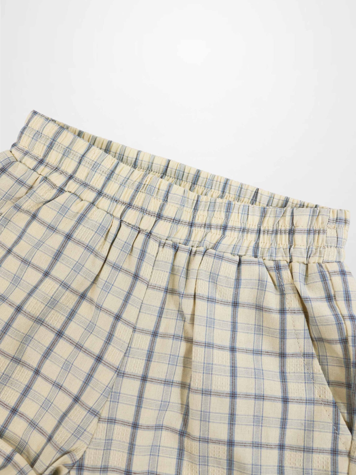 Beige plaid shorts with blue grid pattern and elastic waistband.