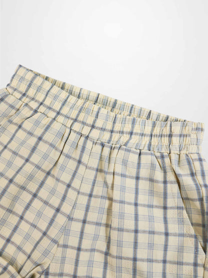 Beige plaid shorts with blue grid pattern and elastic waistband.