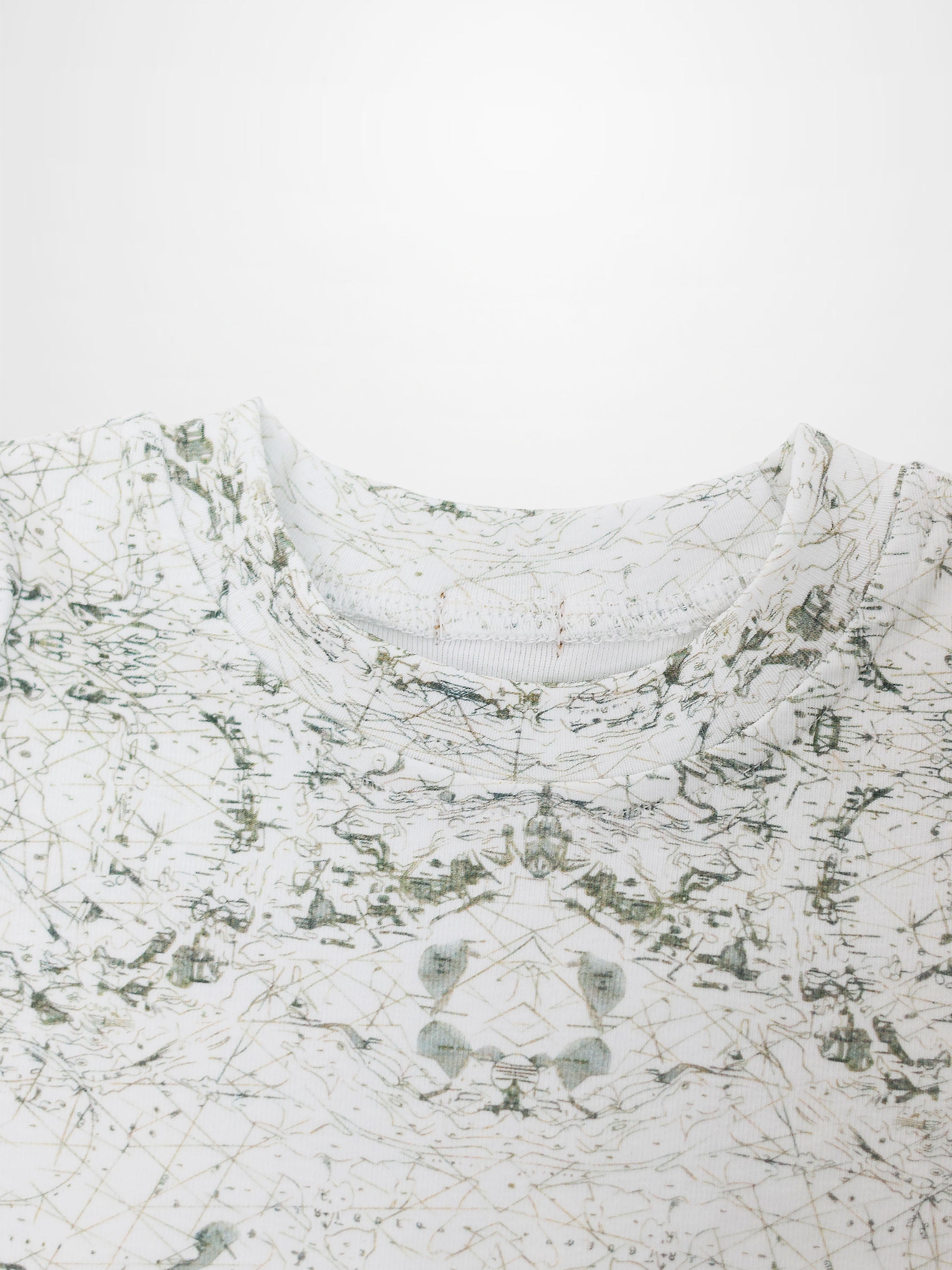 Map T-shirt with sage-green vintage map print on off-white fabric; compass markers and geographic lines.