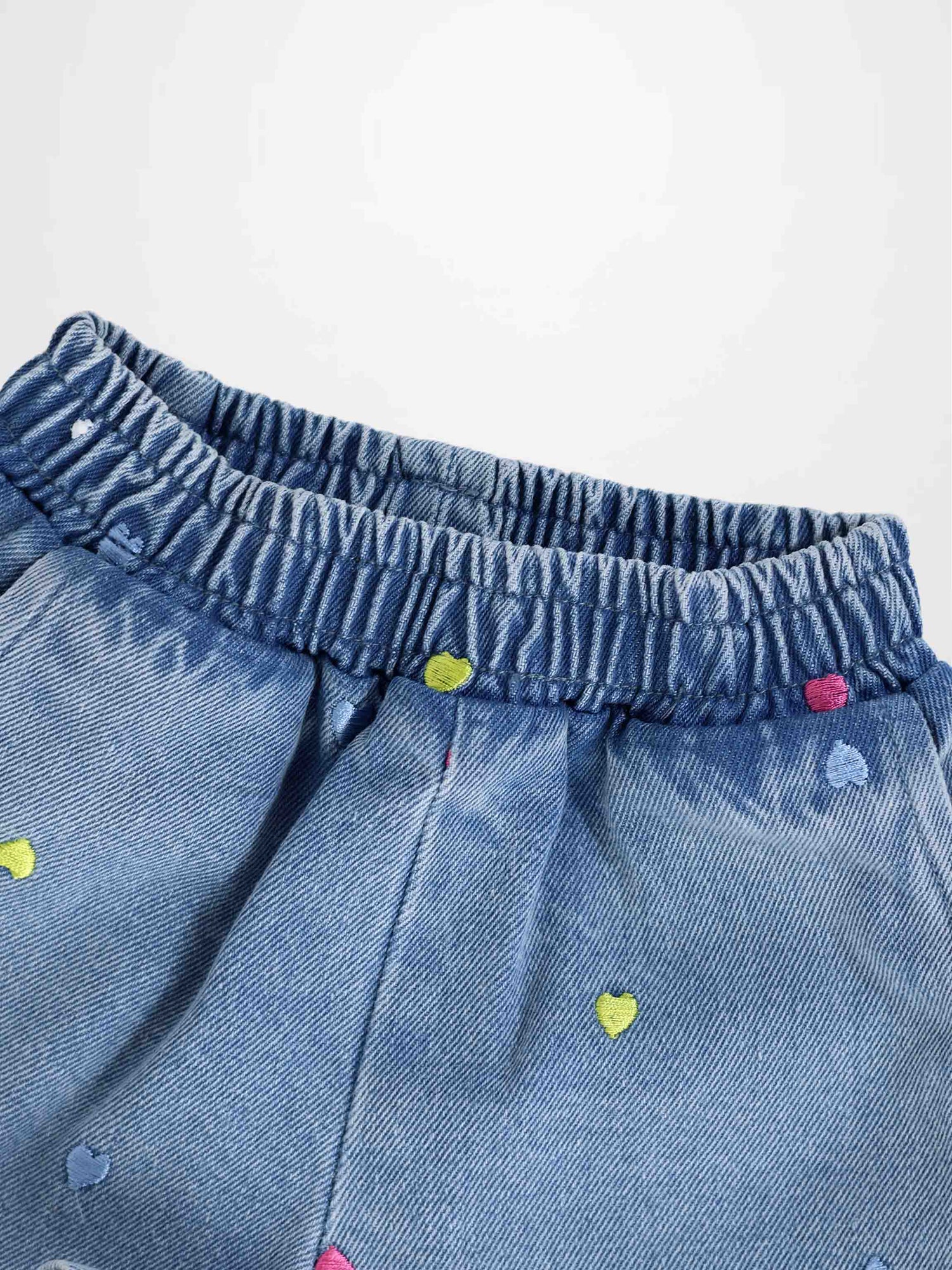 Blue denim shorts with an elastic waistband and colorful embroidered hearts.