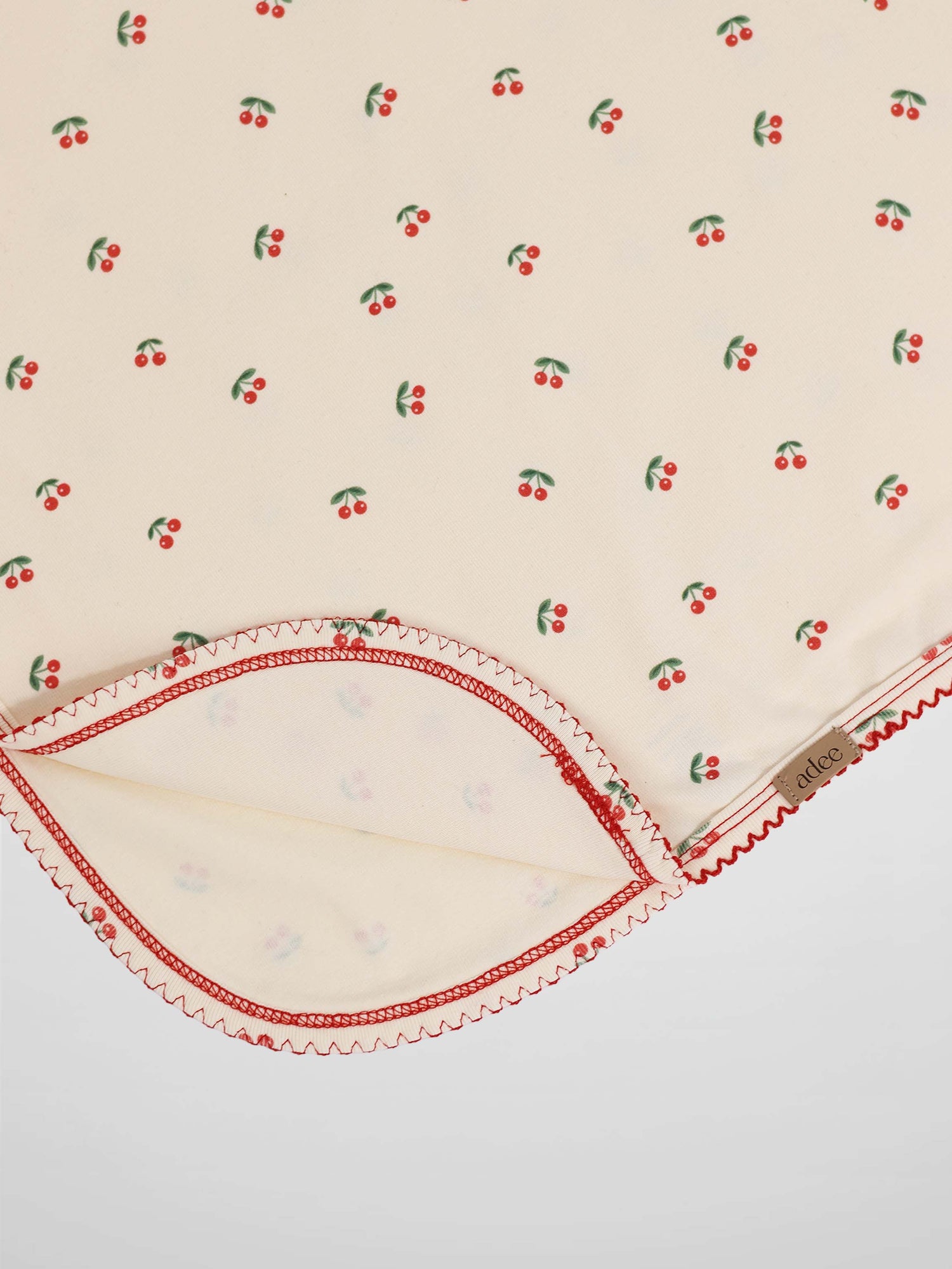 Red Cherry Blanket with Lace receiving blanket by Adee; cream fabric with scattered red cherries and red trim