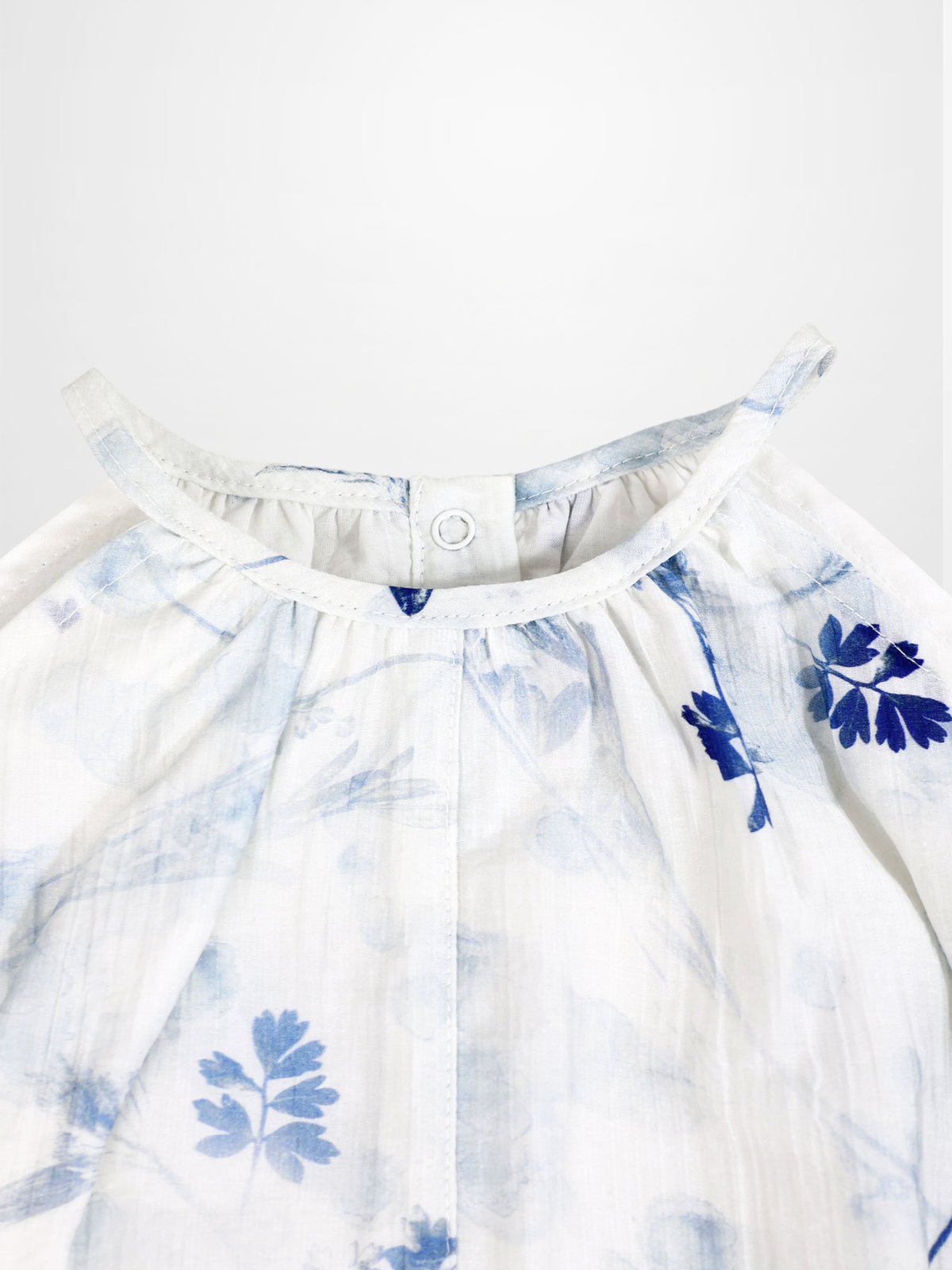 Blue Flower Romper for girls by Adee; dressy white fabric with blue floral print and back neck snap.