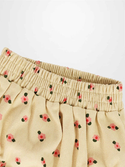 Tan floral bloomers for girls with an elastic shirred waistband and pink flower print fabric.