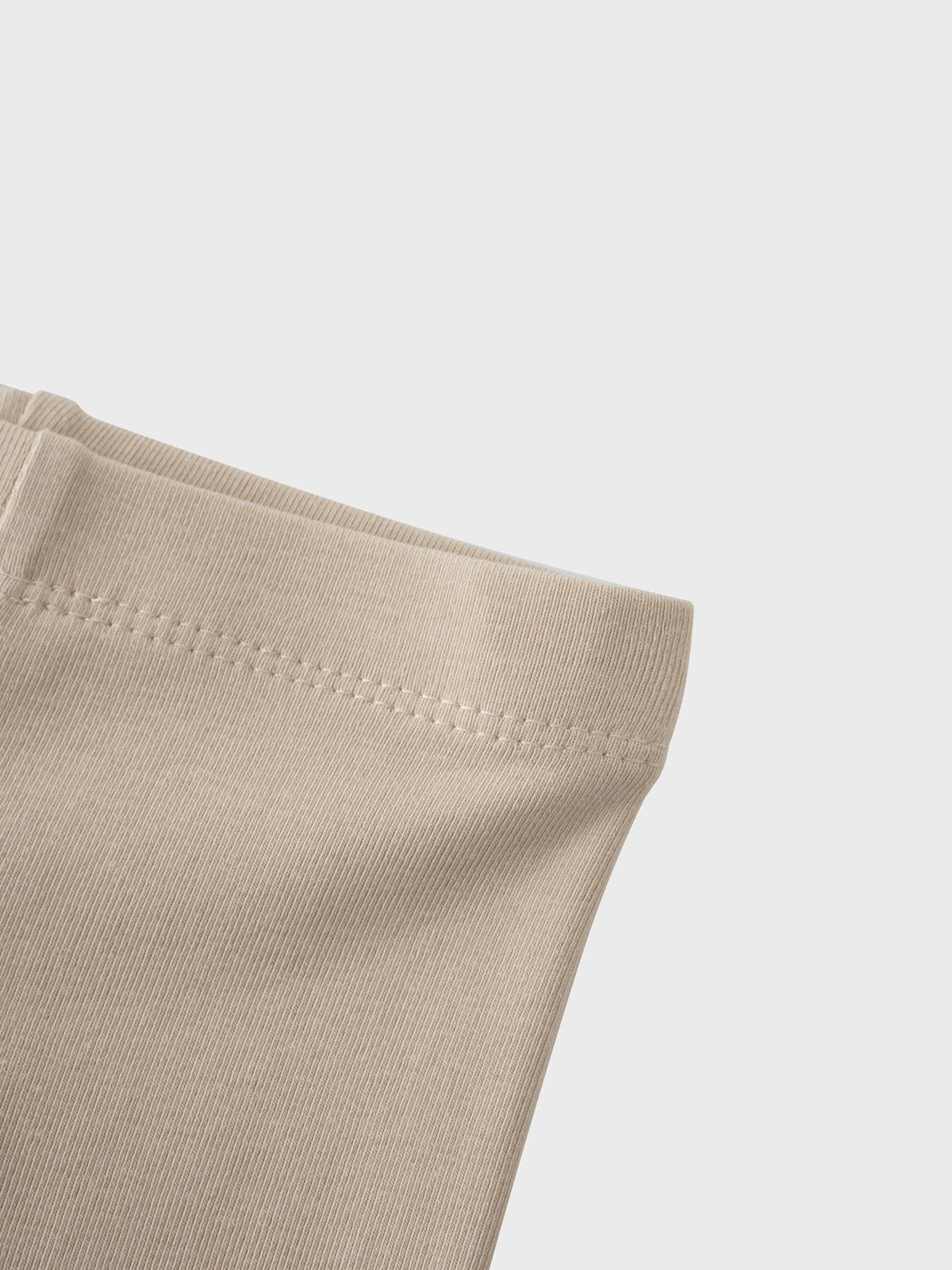 Non ribbed leggings taupe fabric with visible waistband stitching.