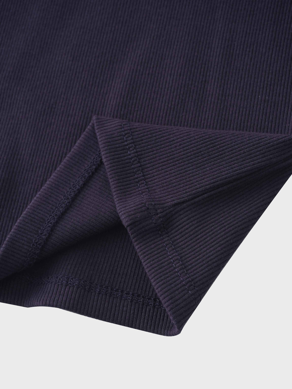 Close-up of navy crossover thin ribbed pajama fabric with a folded sleeve cuff.
