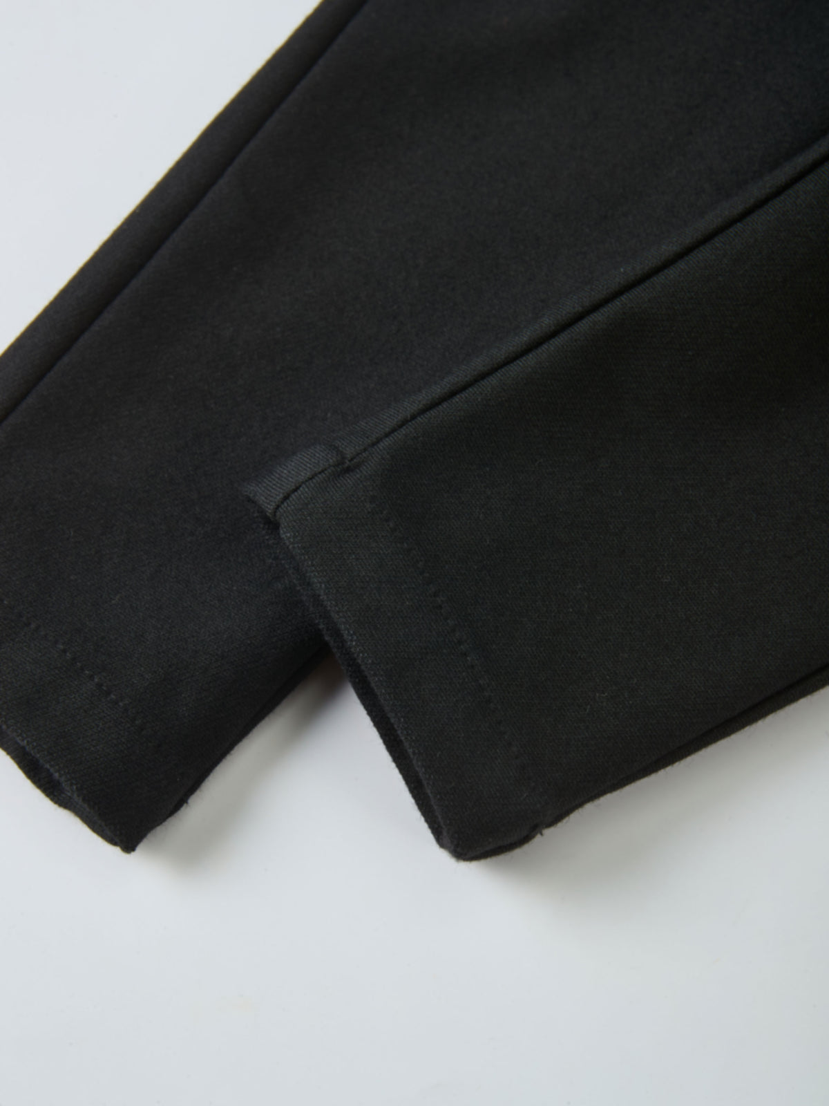 Denim overalls by Adee in black, unisex; close-up of fabric and seam.