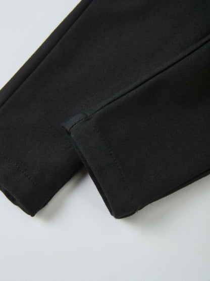 Denim overalls by Adee in black, unisex; close-up of fabric and seam.