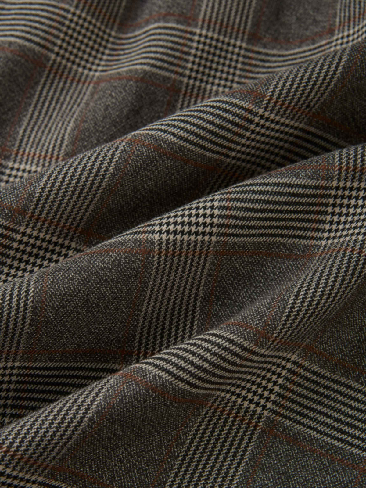 Plaid dress fabric in grey with small checks and brown accents.