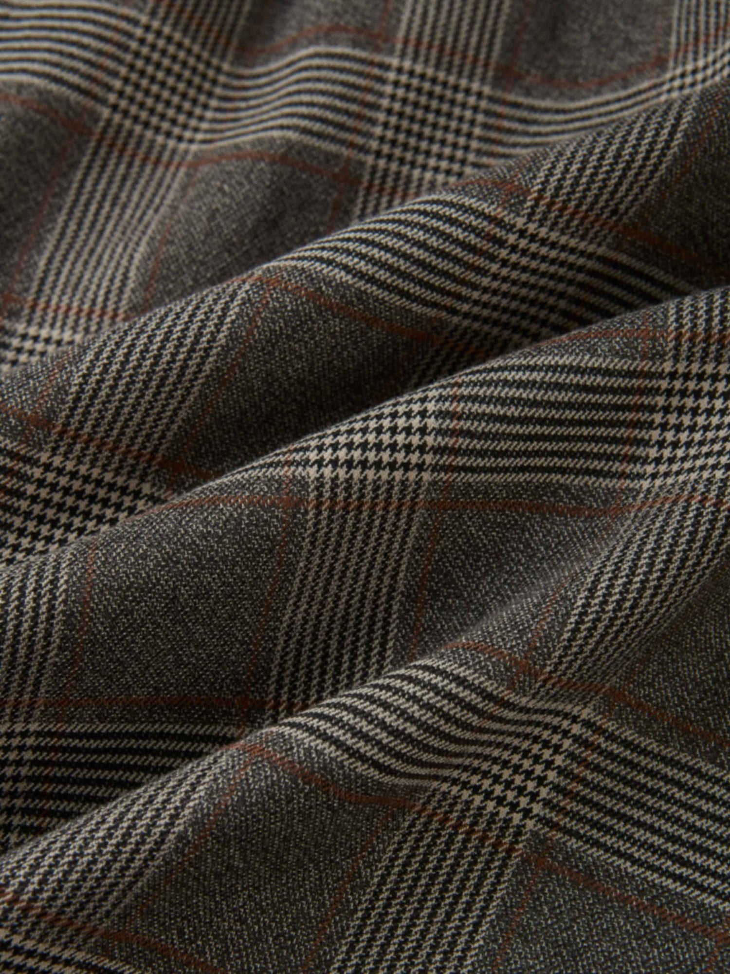 Plaid dress fabric in grey with small checks and brown accents.