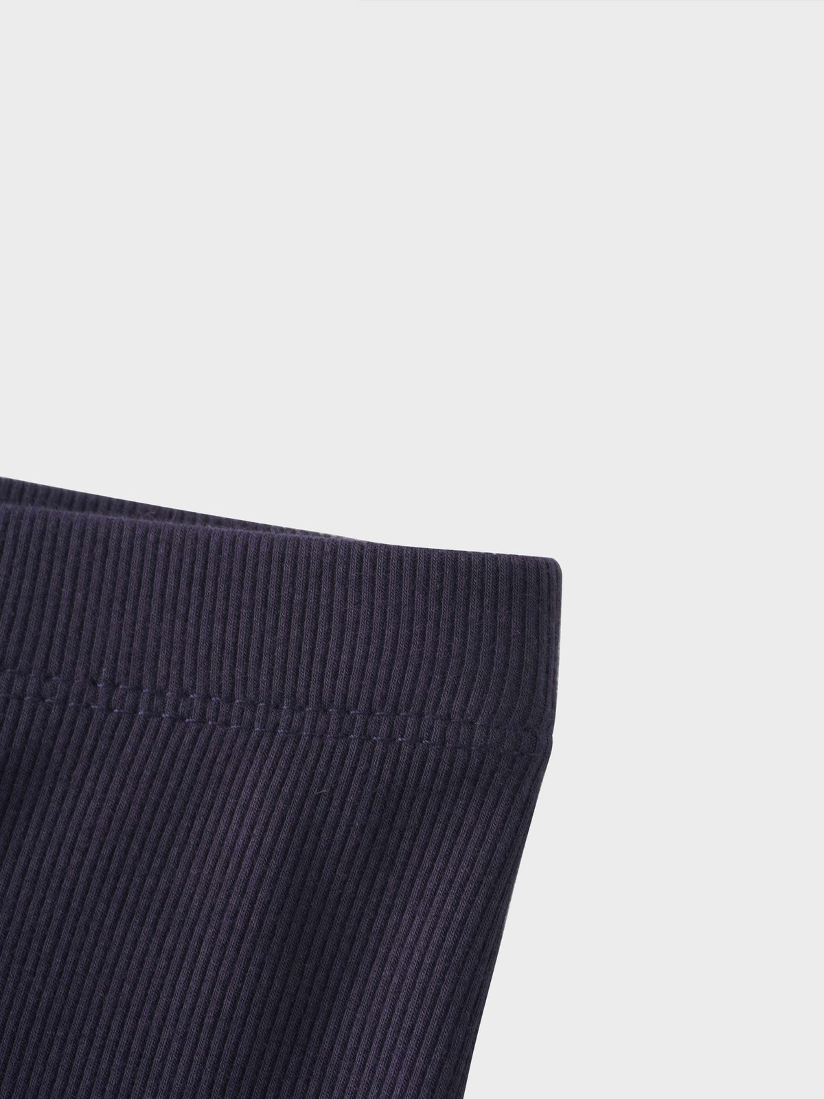 Close-up of navy thin ribbed fabric cuff on crossover pajama set.
