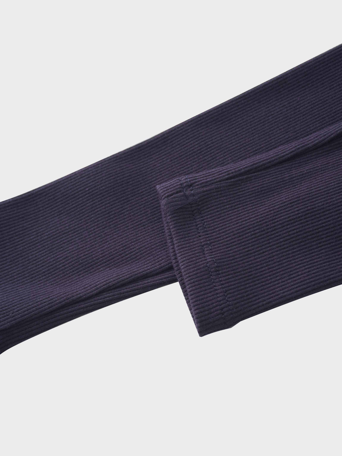 Close-up of navy thin-ribbed pajama sleeve with cuff detail.
