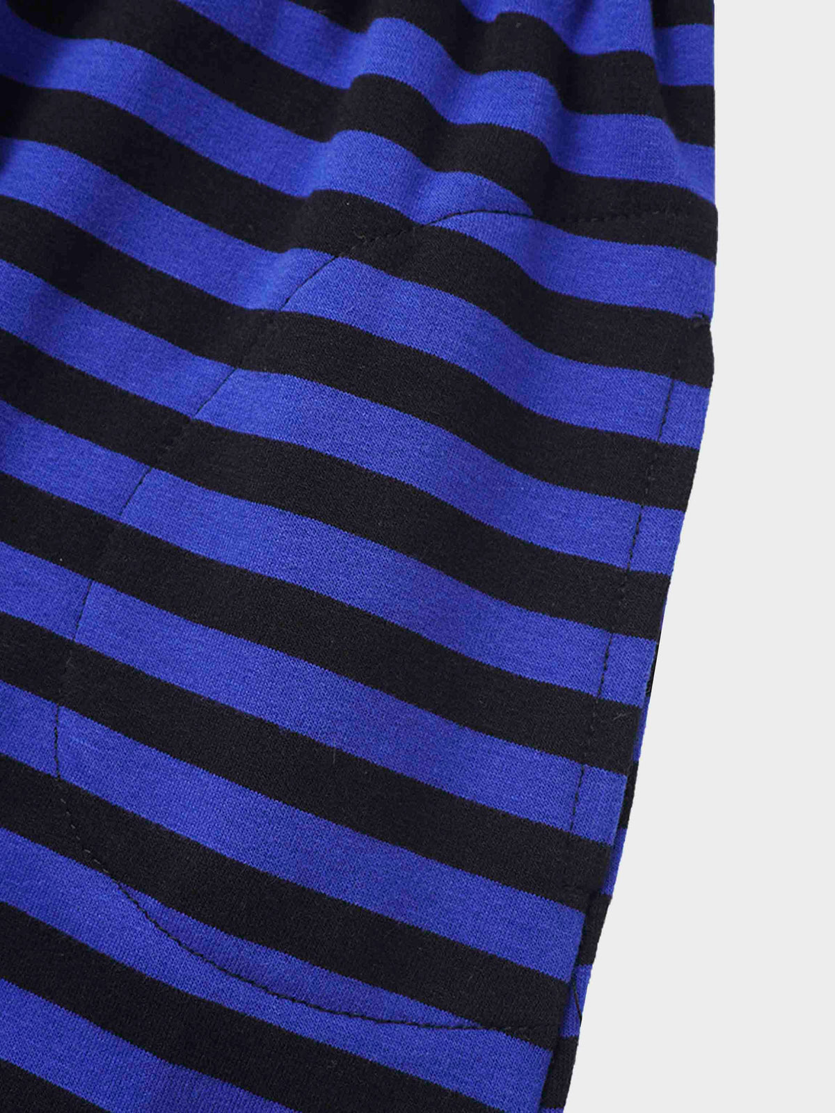 Blue and black striped knit fabric close-up, hinting at a cozy girls&