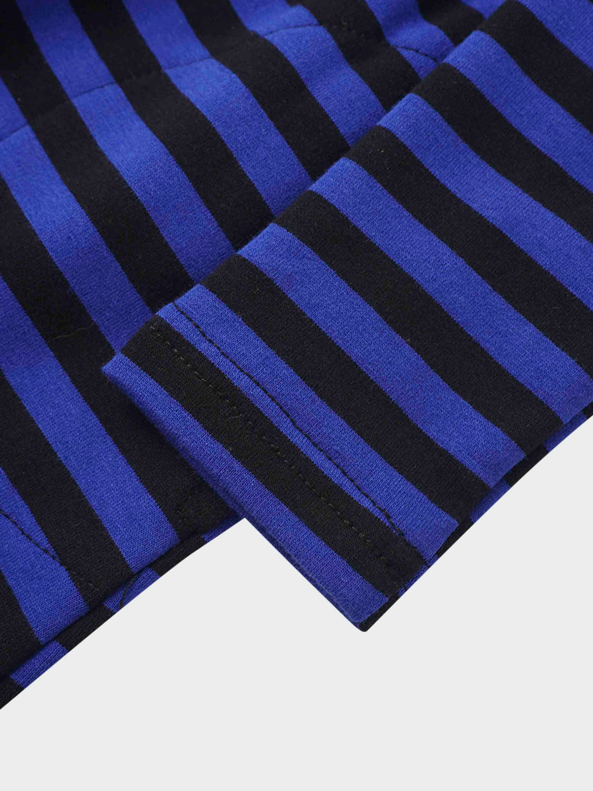 Close-up of blue and black striped knit fabric with stitched cuff detail.