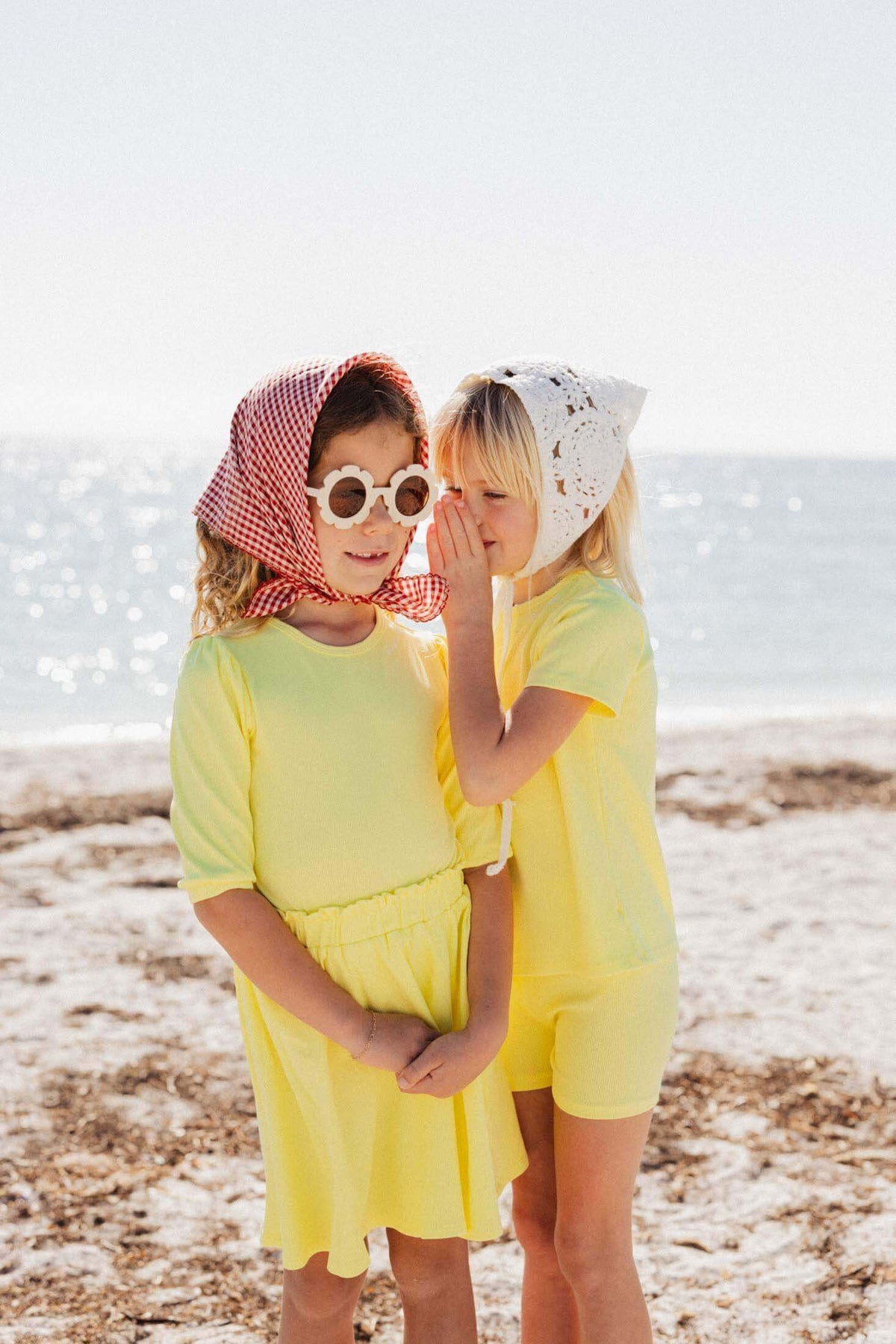 Girls wearing yellow ribbed short set on beach