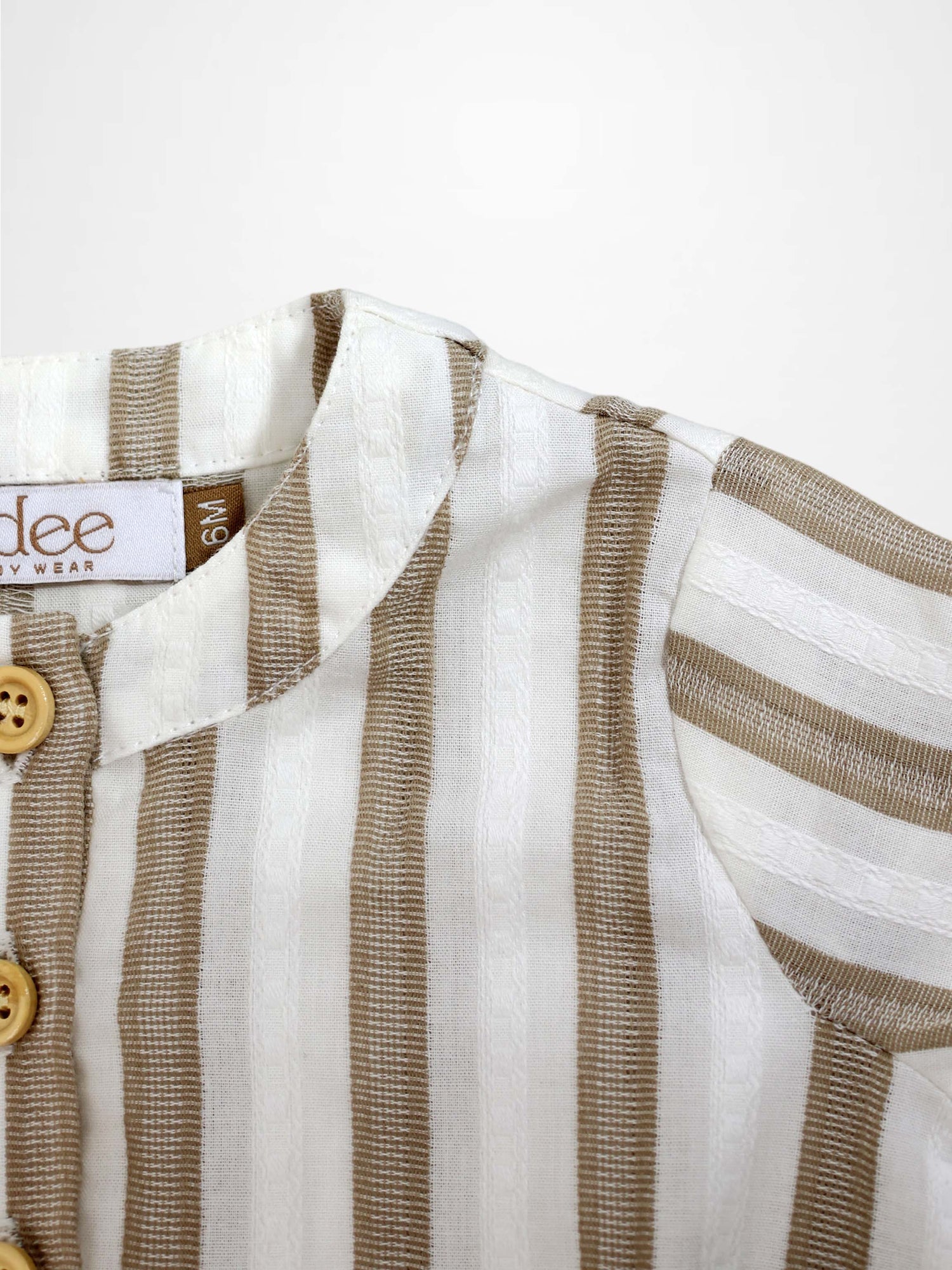 Tan and white striped romper with a collar and wooden buttons.