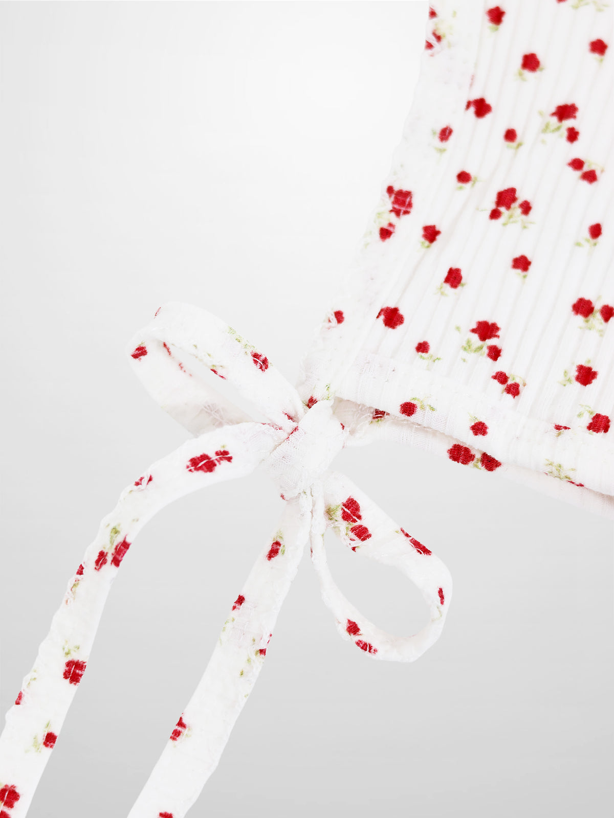 Red flower bonnet for girls with white fabric and delicate red flowers, tie straps.