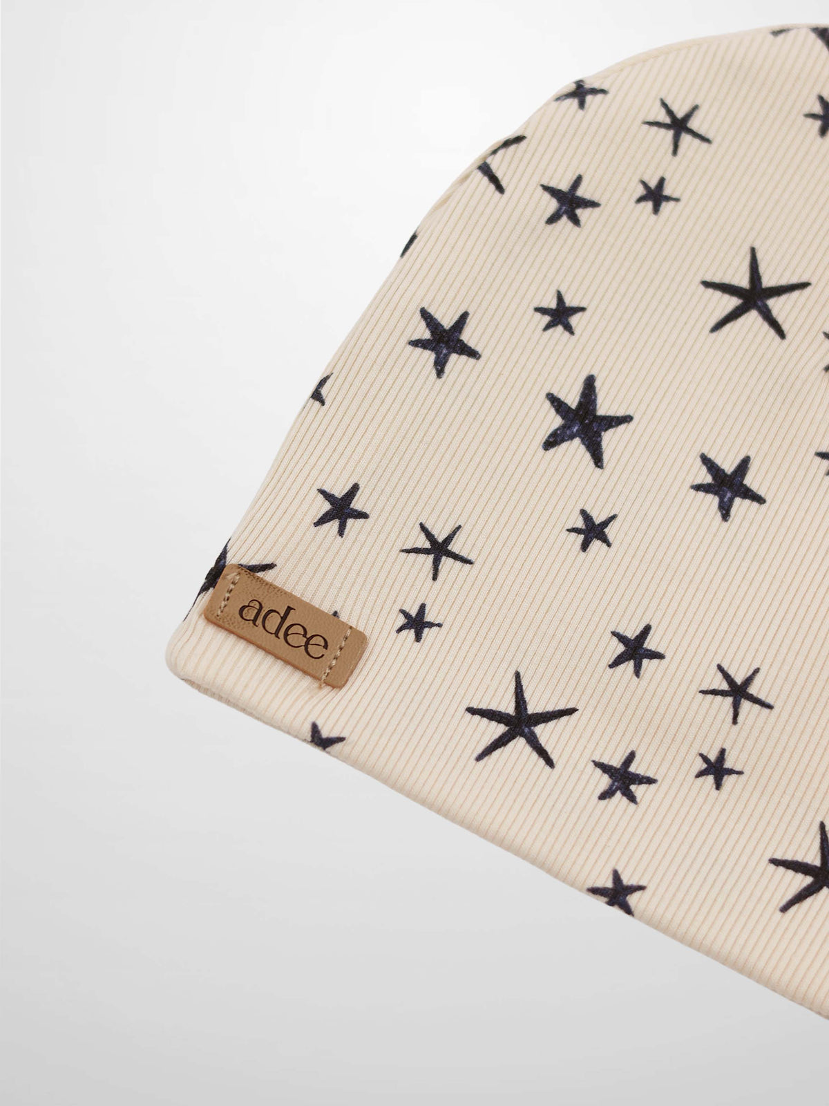Star Beanie for boys; light beige knit with navy star pattern and Adee label.