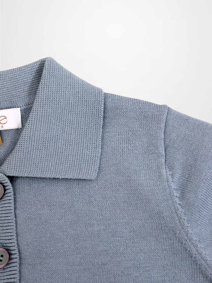 Light blue knit sweater with polo collar and button placket, close-up knit texture.