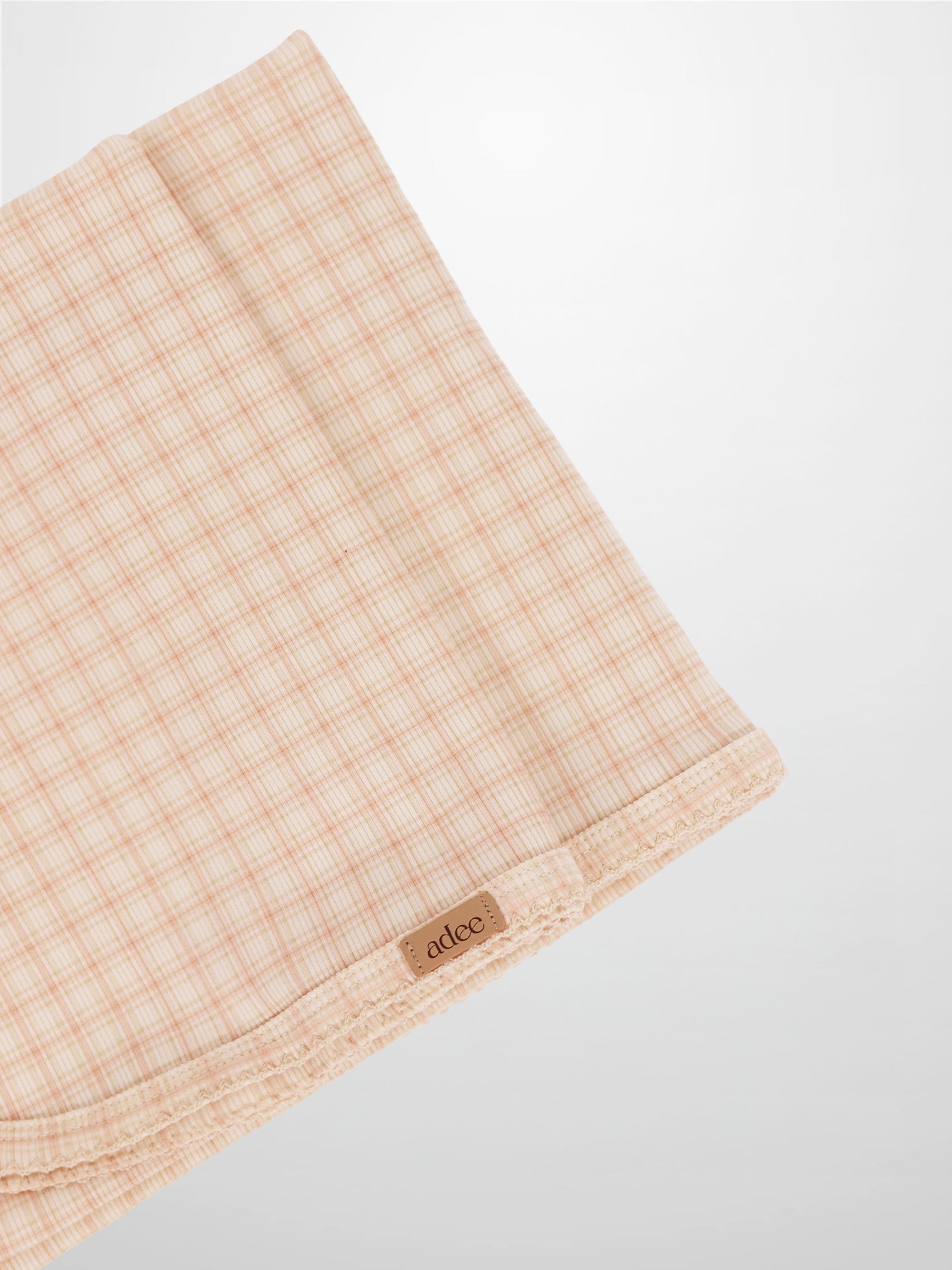 Oatmeal Grid Blanket - Pink, light pink grid lines on a girls receiving blanket with Adee brand tag visible