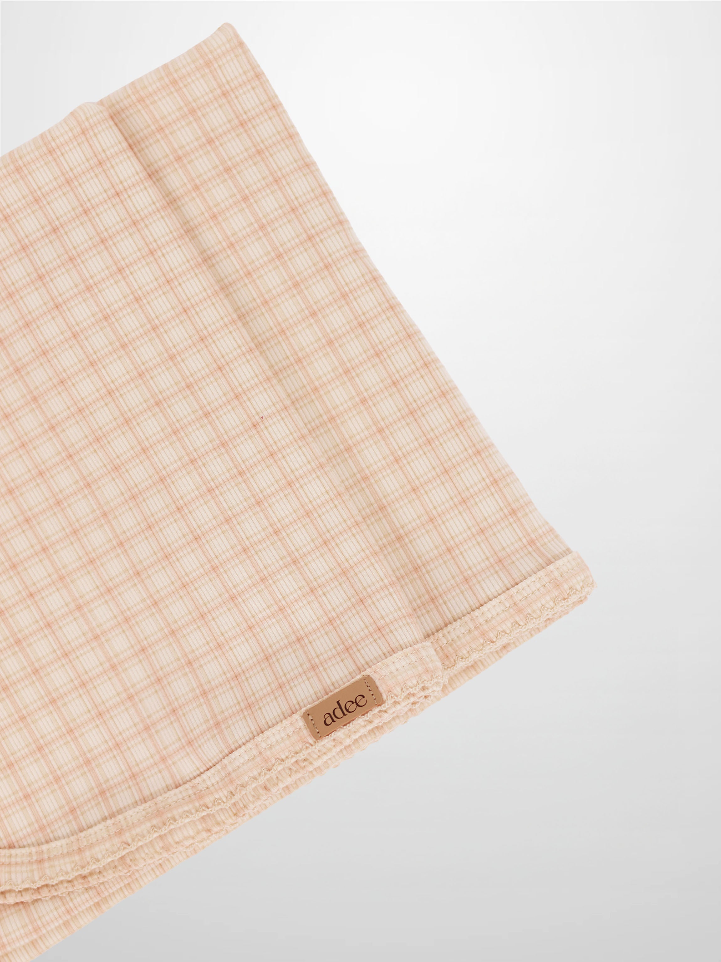 Oatmeal Grid Blanket - Pink, light pink grid lines on a girls receiving blanket with Adee brand tag visible