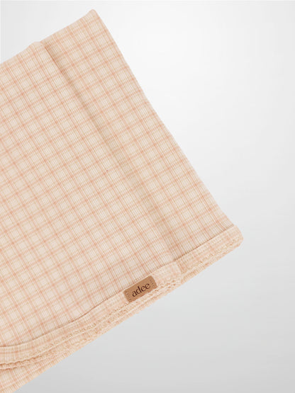 Oatmeal Grid Blanket - Pink, light pink grid lines on a girls receiving blanket with Adee brand tag visible