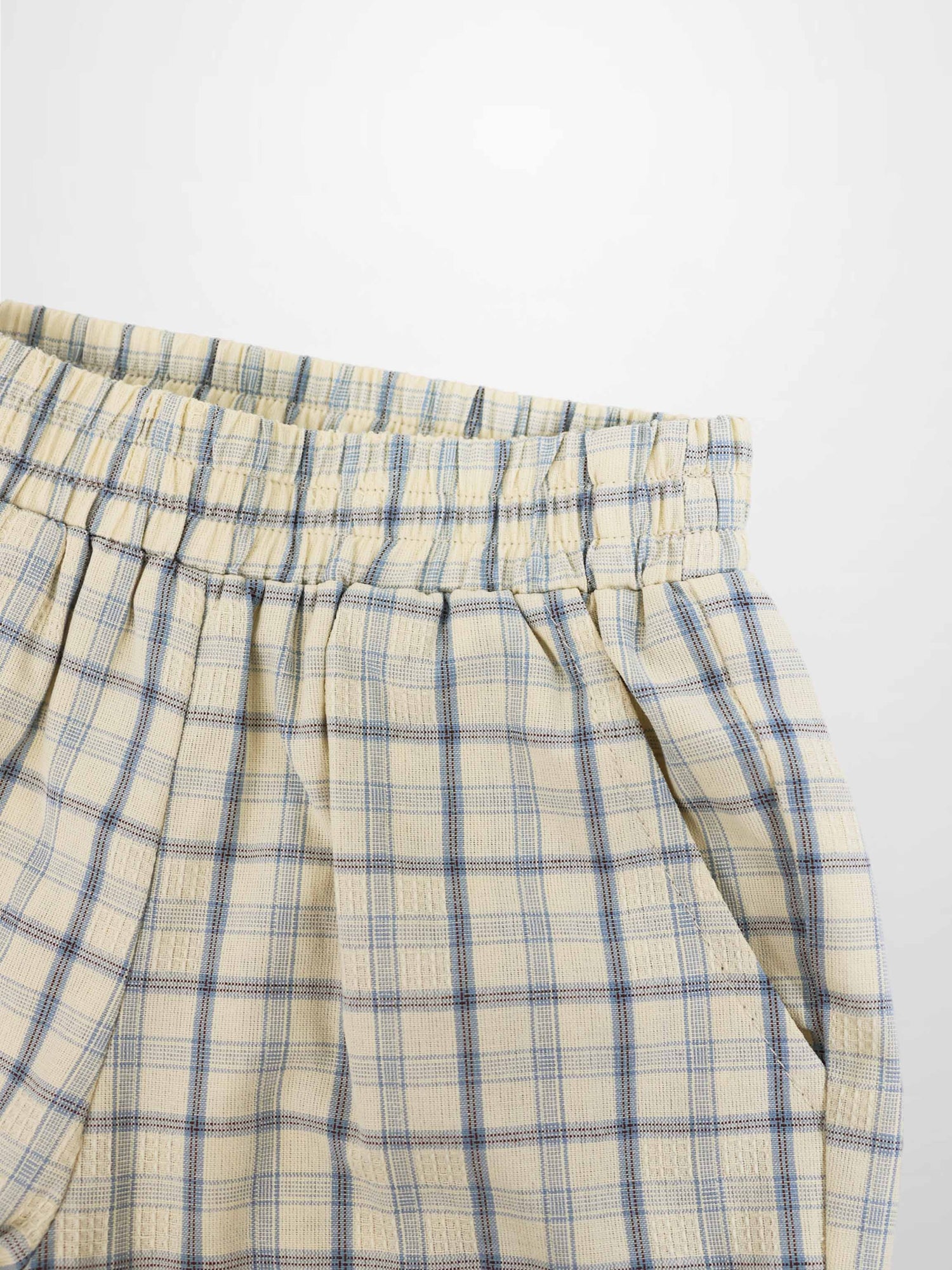 Cream plaid shorts with blue checks, elastic waistband, and front pleats.