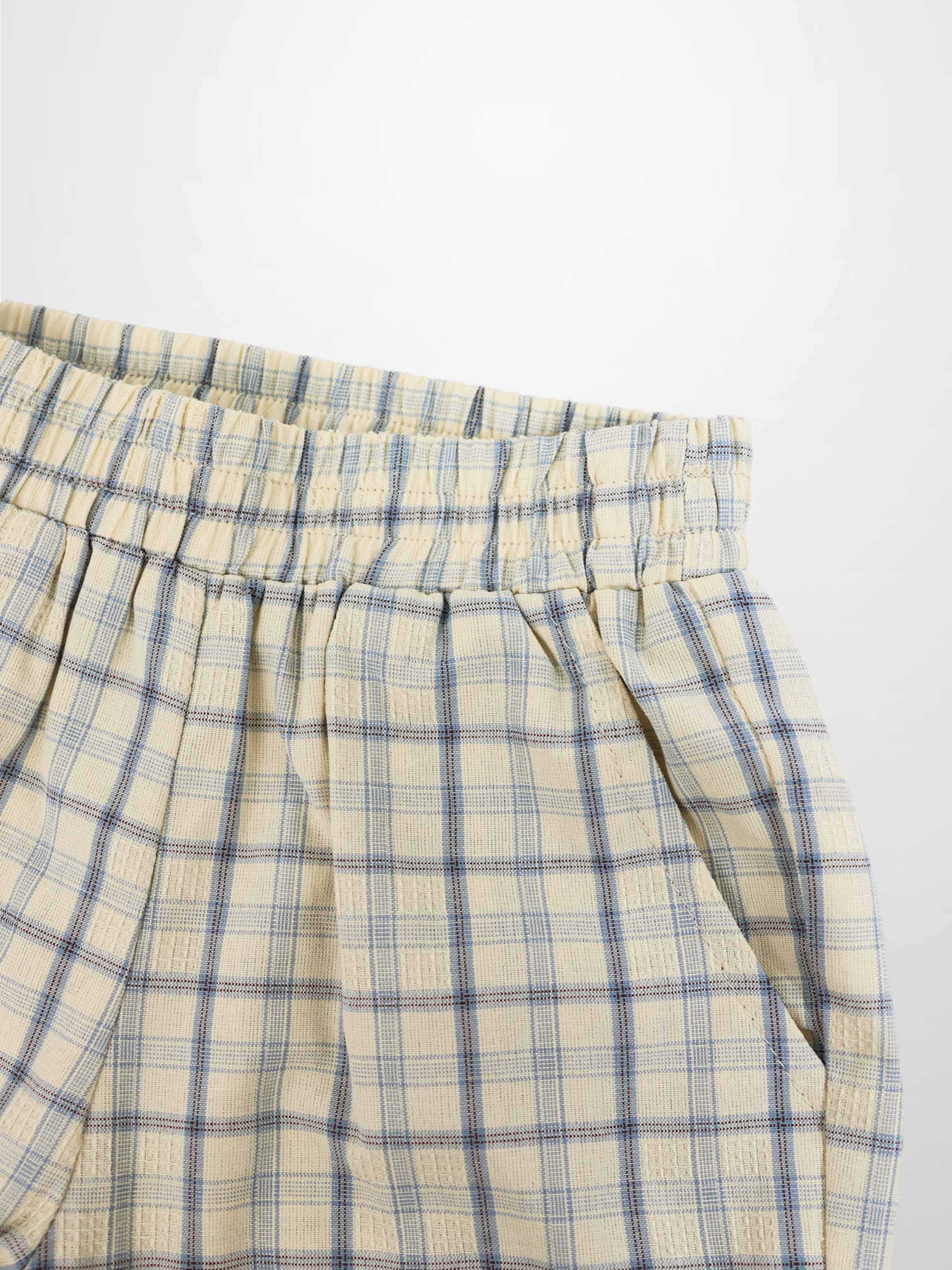 Cream plaid shorts with blue checks, elastic waistband, and front pleats.