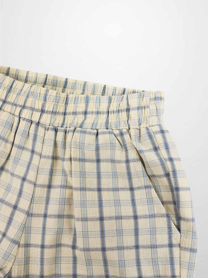 Cream plaid shorts with blue checks, elastic waistband, and front pleats.