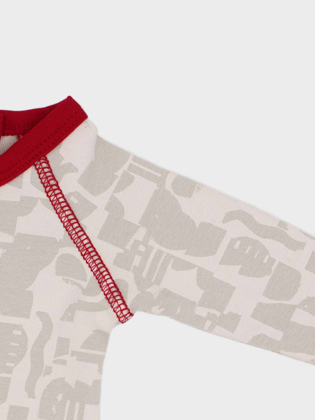 Abstract-print stretchy red baby jumpsuit footie with neutral tones and red trim.