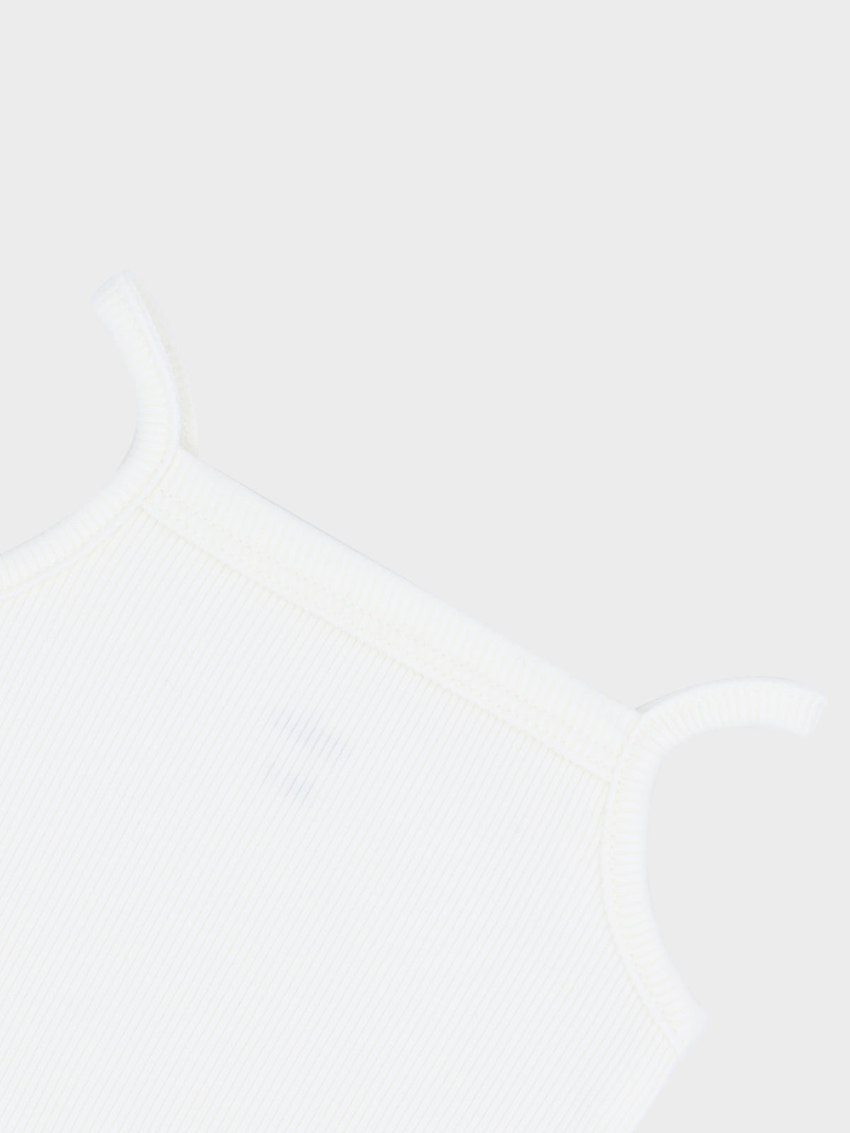 White ribbed undershirt with thin straps, close-up of fabric texture.