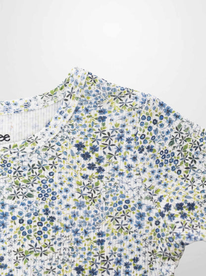 Blue floral pajamas top with small blue flowers and green leaves on white fabric.