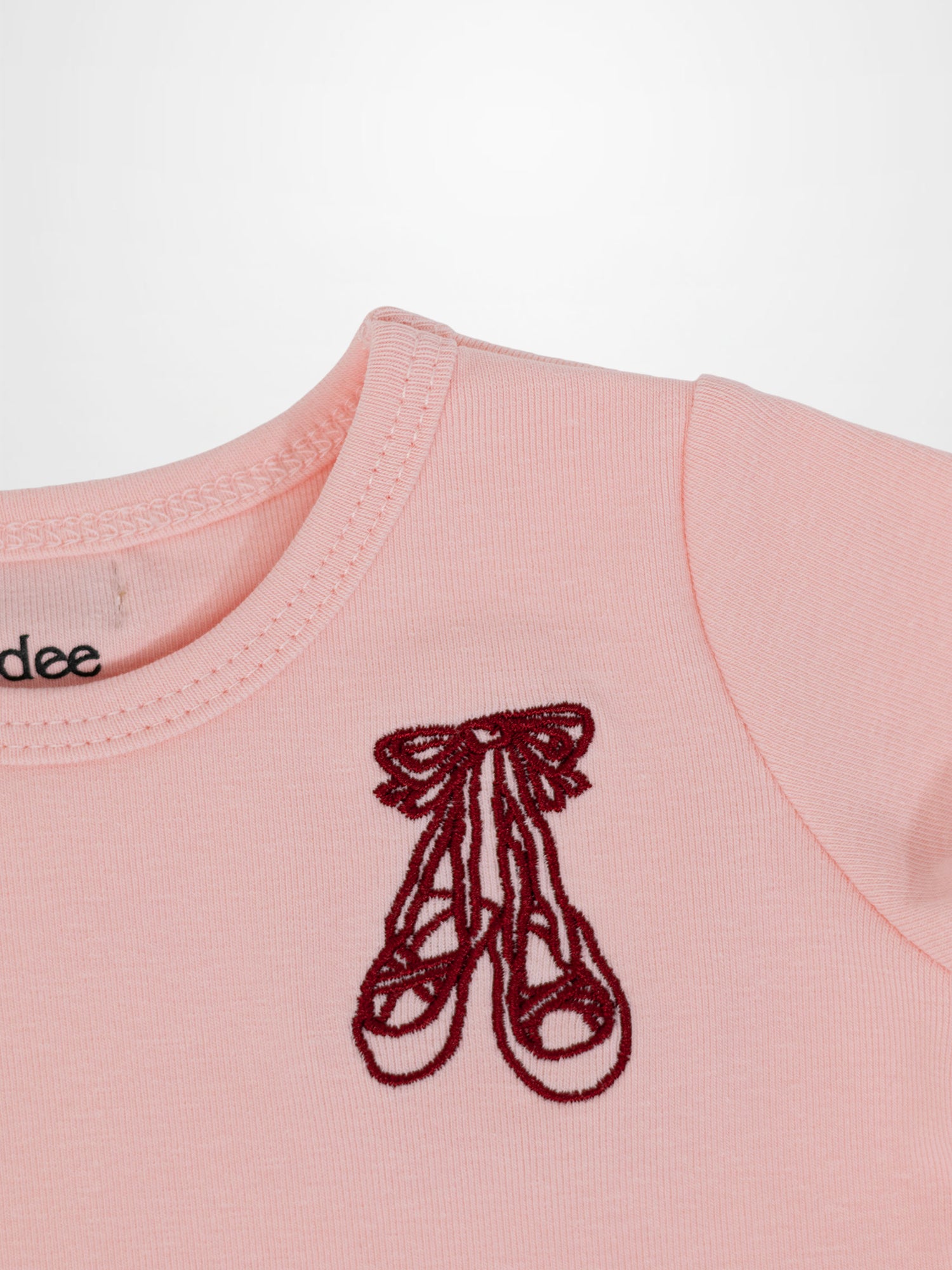 Short sleeve emblem T-shirt by Adee in light pink with burgundy ballet shoe embroidery.
