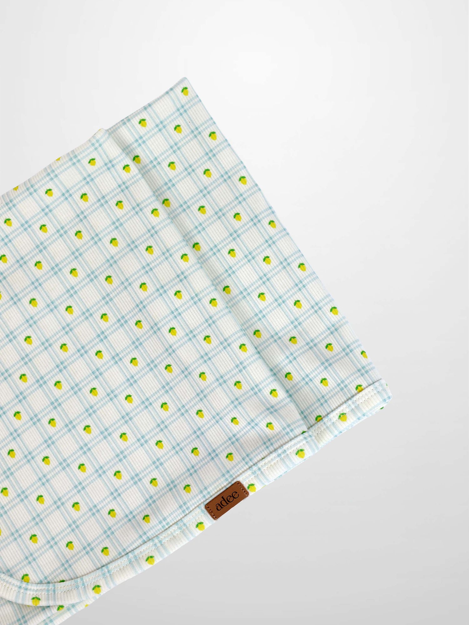 Lemon Window Blanket by Adee; boys swaddle blanket in white with light blue plaid and small lemon motifs.
