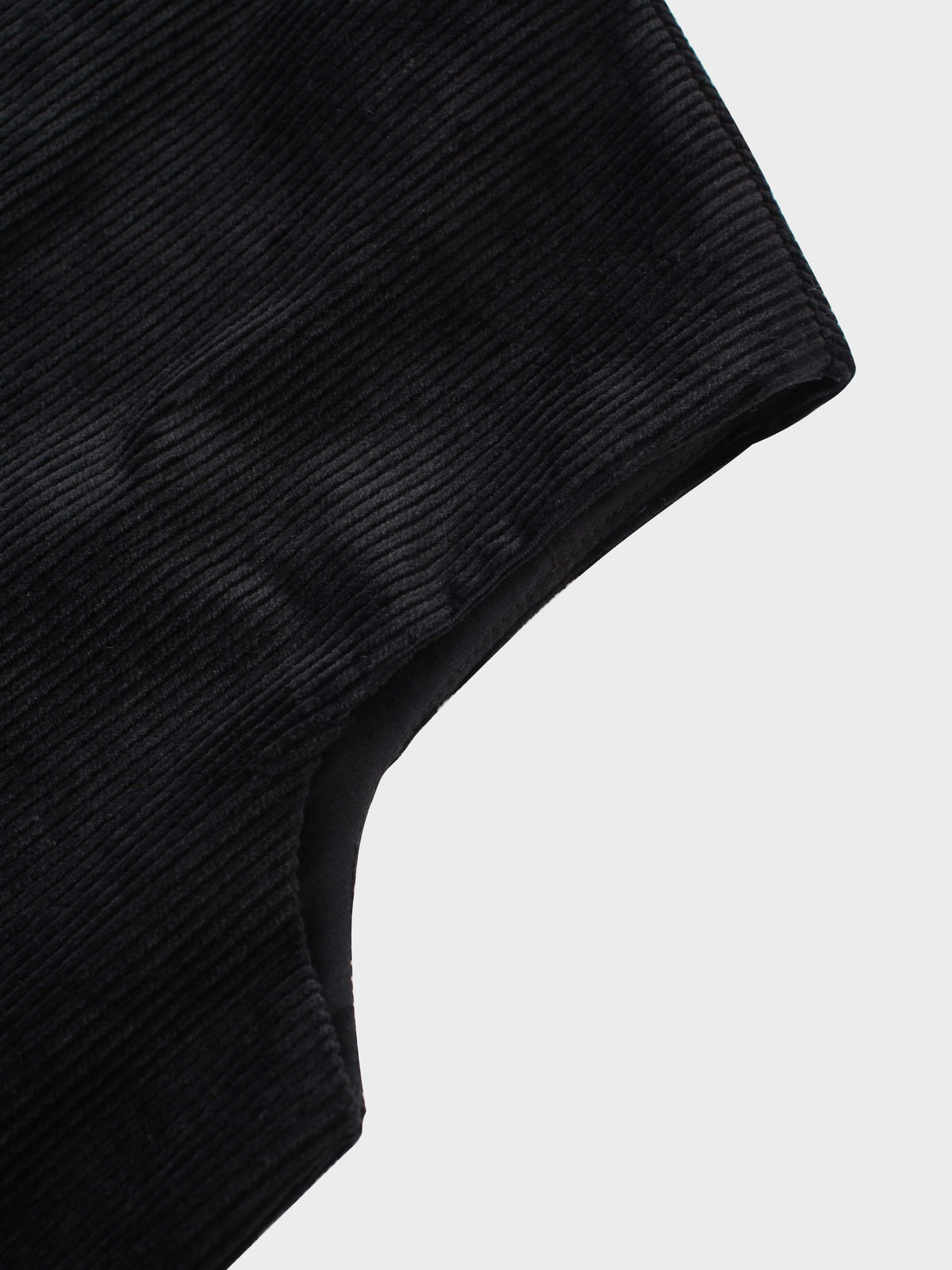 Black corduroy jumper with A-line silhouette, round neckline, patch pockets, and hidden back.