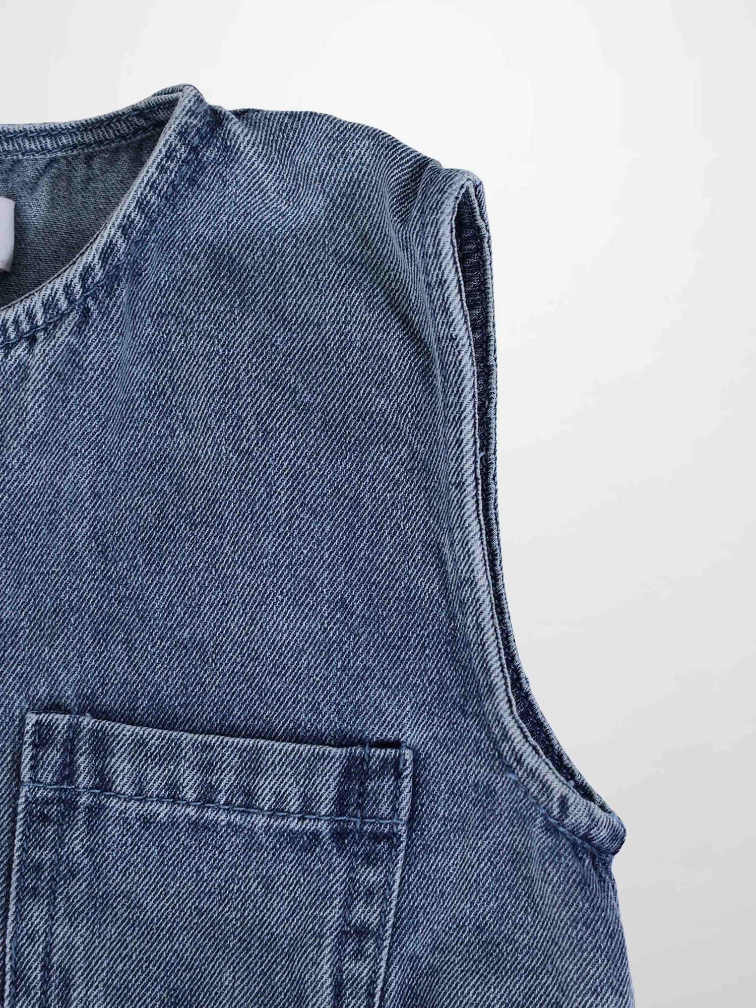 Blue denim romper for boys with sleeveless design and front pocket