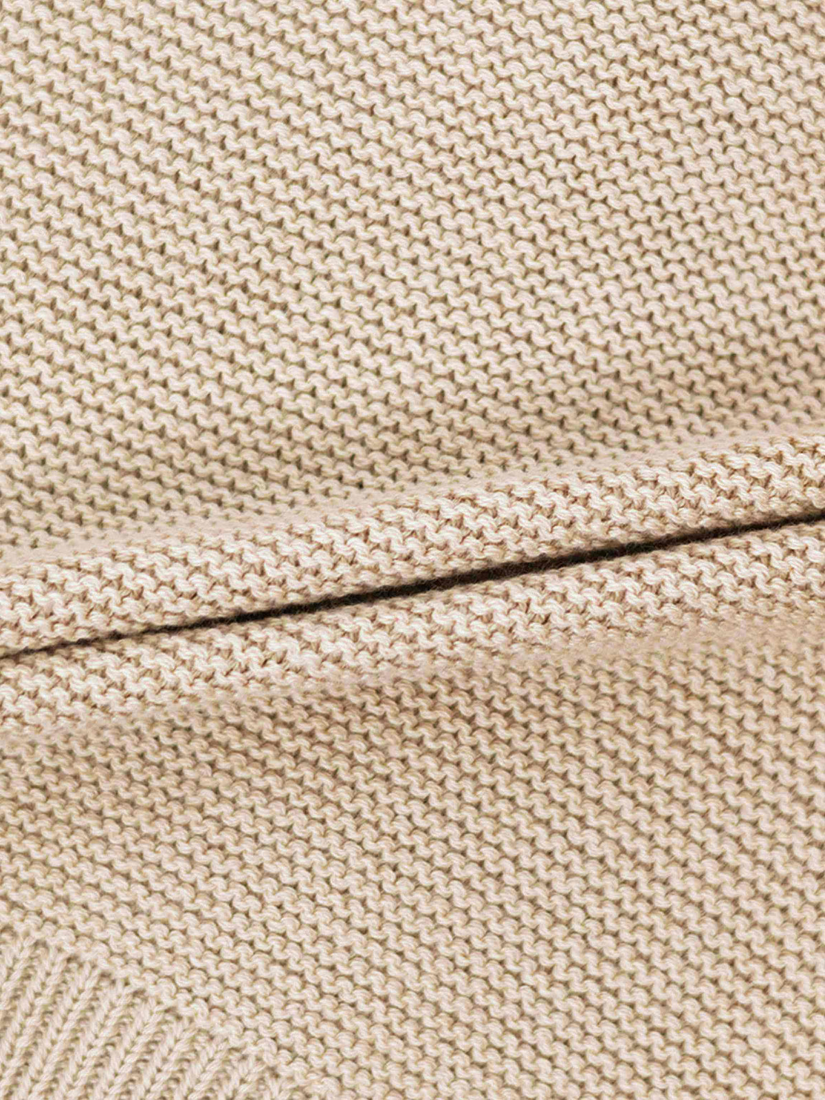 Cropped cardigan in ivory knit; close-up reveals tight woven texture for a versatile unisex dressy top.