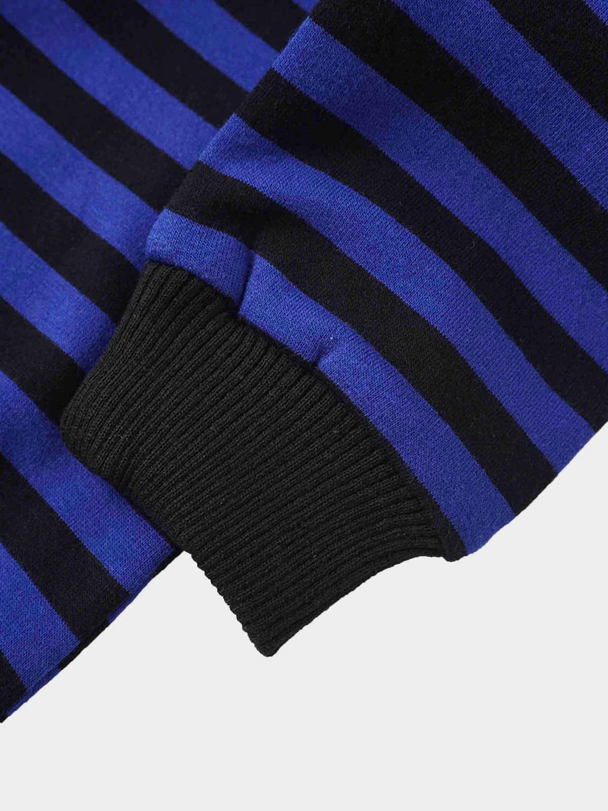 Close-up of blue and black striped sweatshirt sleeve with a black ribbed cuff.