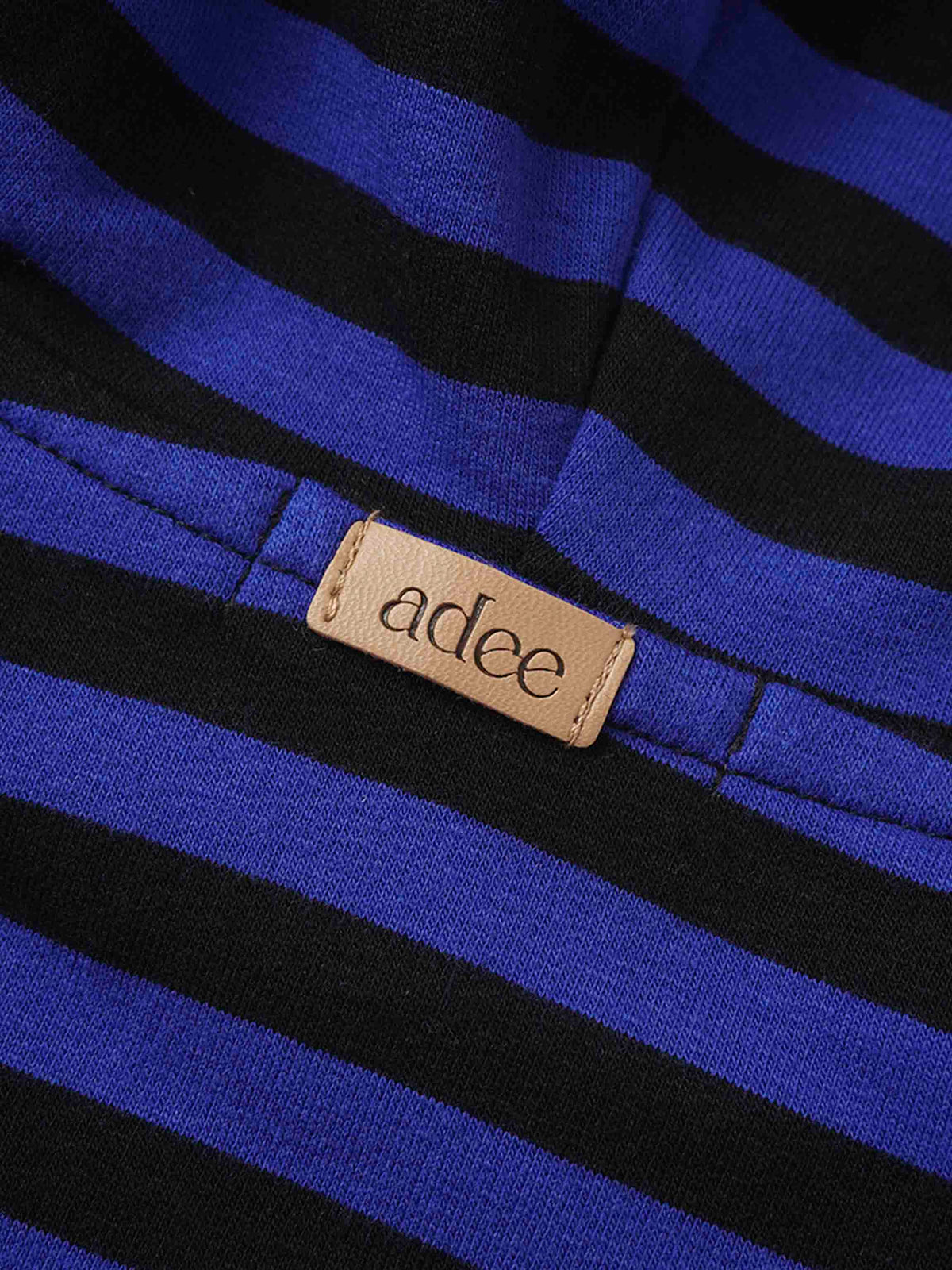 Blue and black striped sweatshirt fabric with a beige brand tag adee.