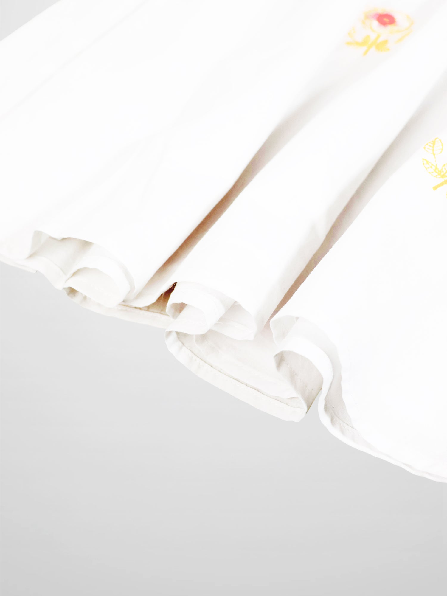 Embroidered Flower Skirt for girls, white dressy skirt with yellow floral embroidery along the edge.